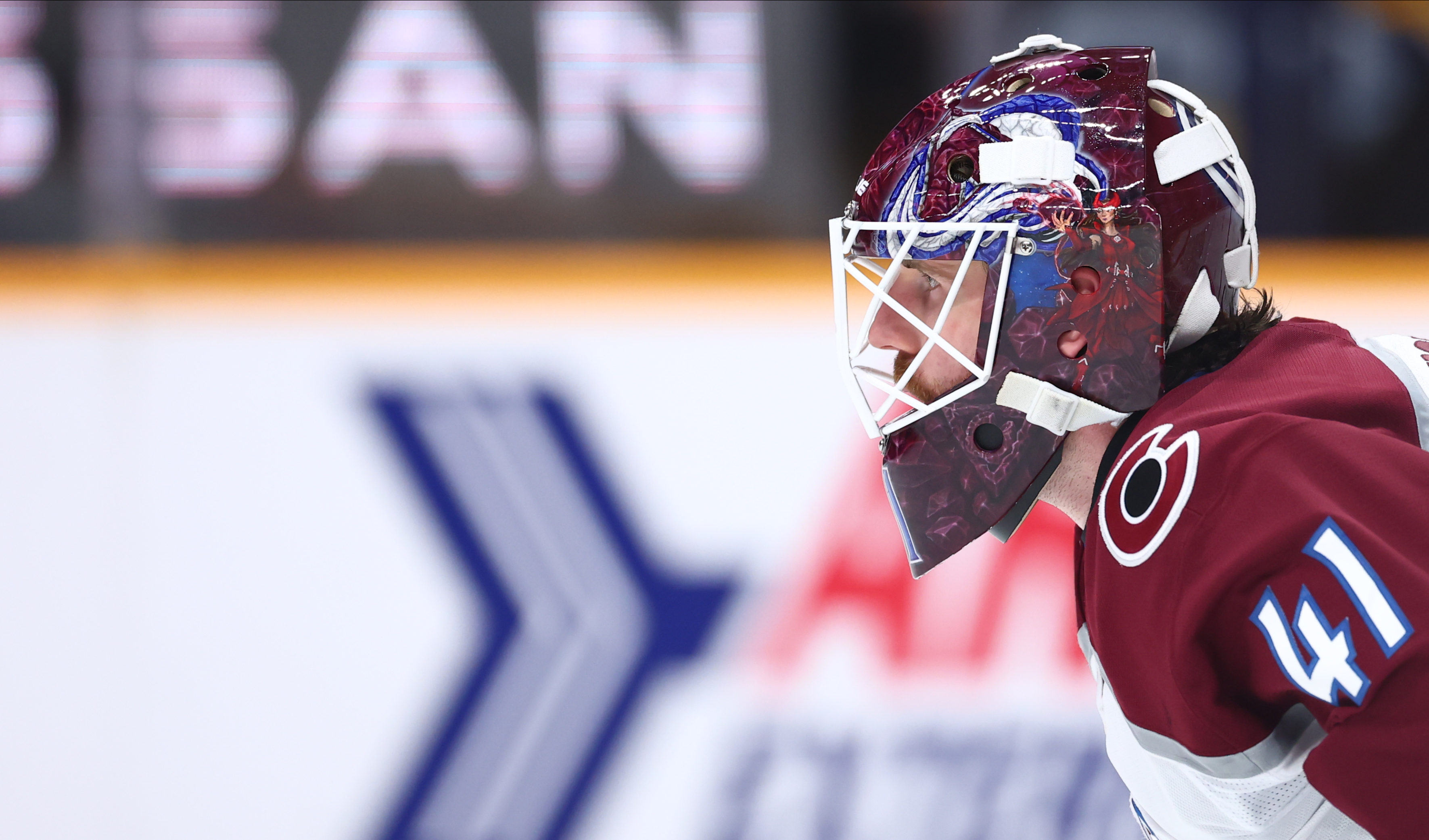 Hockey goalie in maroon jersey #41 wearing a custom mask.