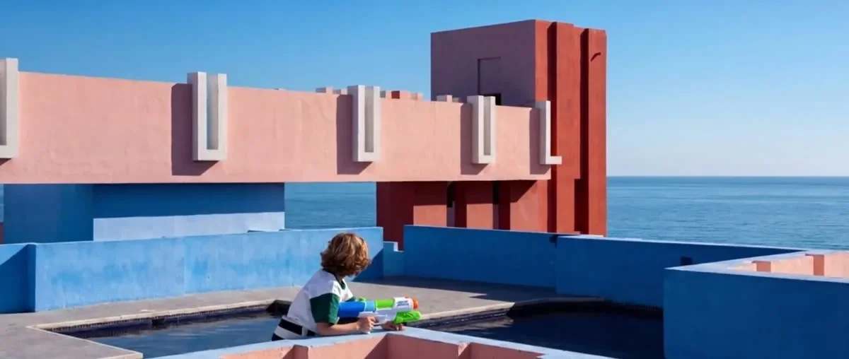 Frame del video LA MURALLA ROJA di Alessandro Ferrauti con architetture rosse e blu affacciate sul mare.