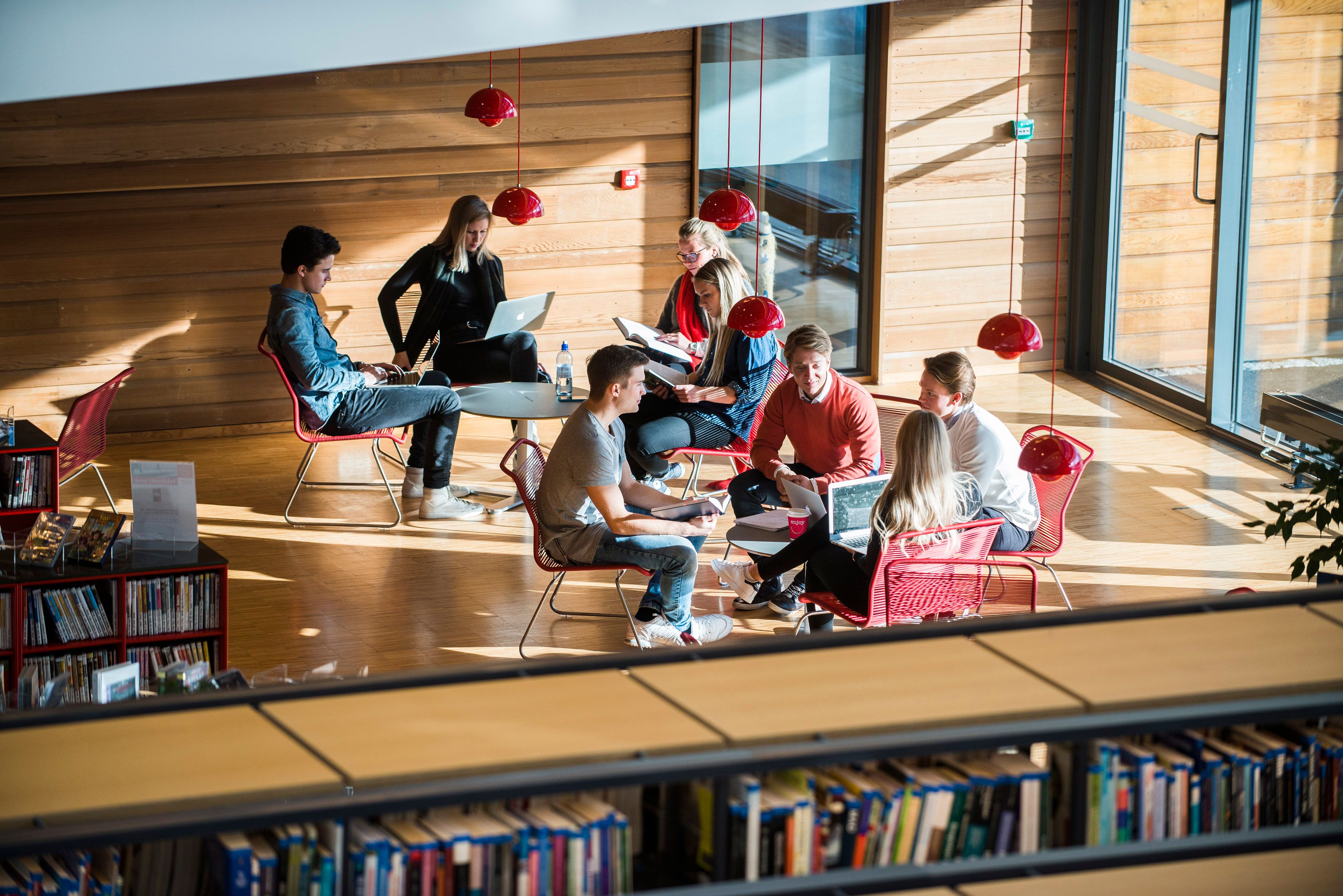 En gruppe med studenter som diskuterer i en kollokviegruppe på en høyskole.