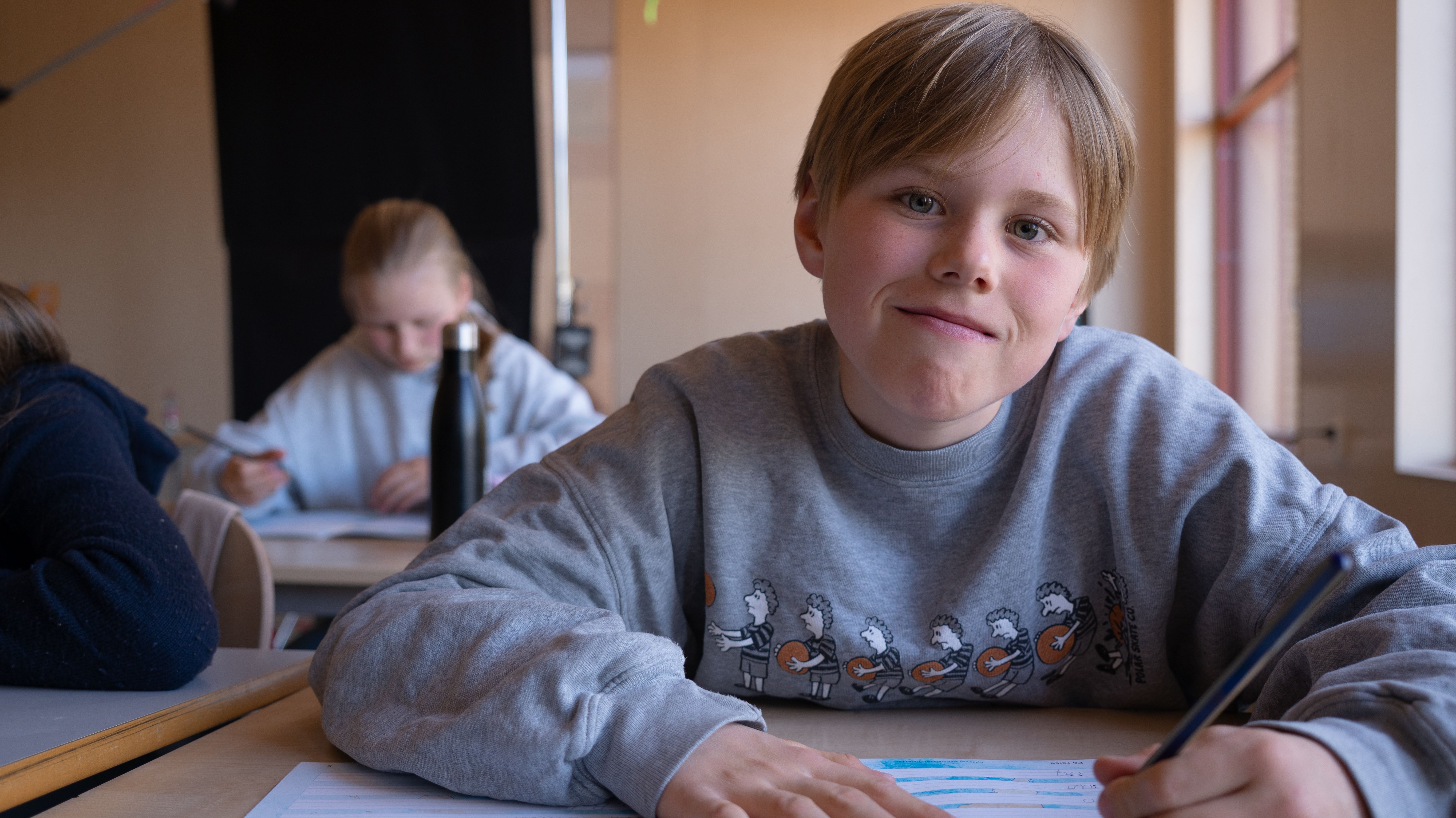 Gutt på skolebenken skriver i arbeidsboka Salto Håndskrift