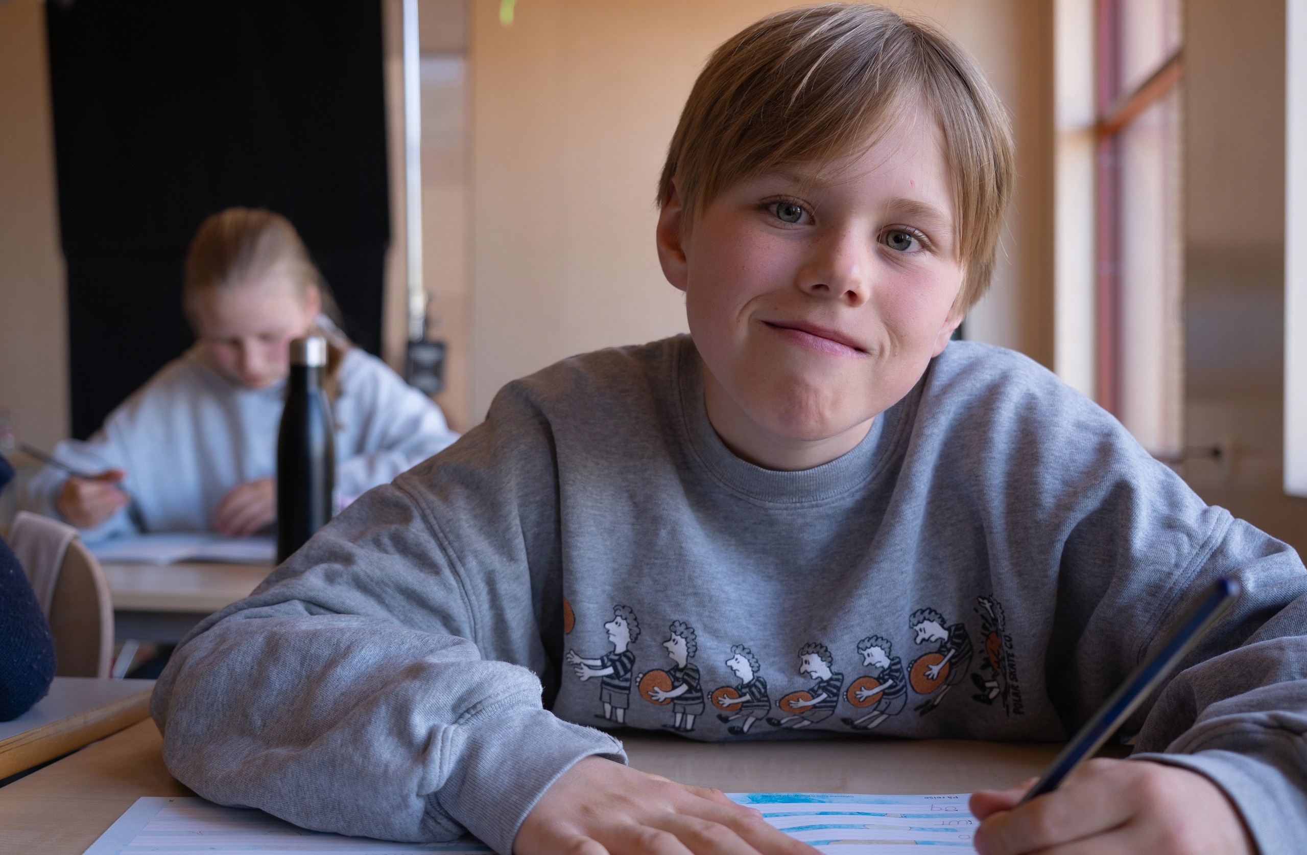 Gutt på skolebenken skriver i arbeidsboka Salto Håndskrift