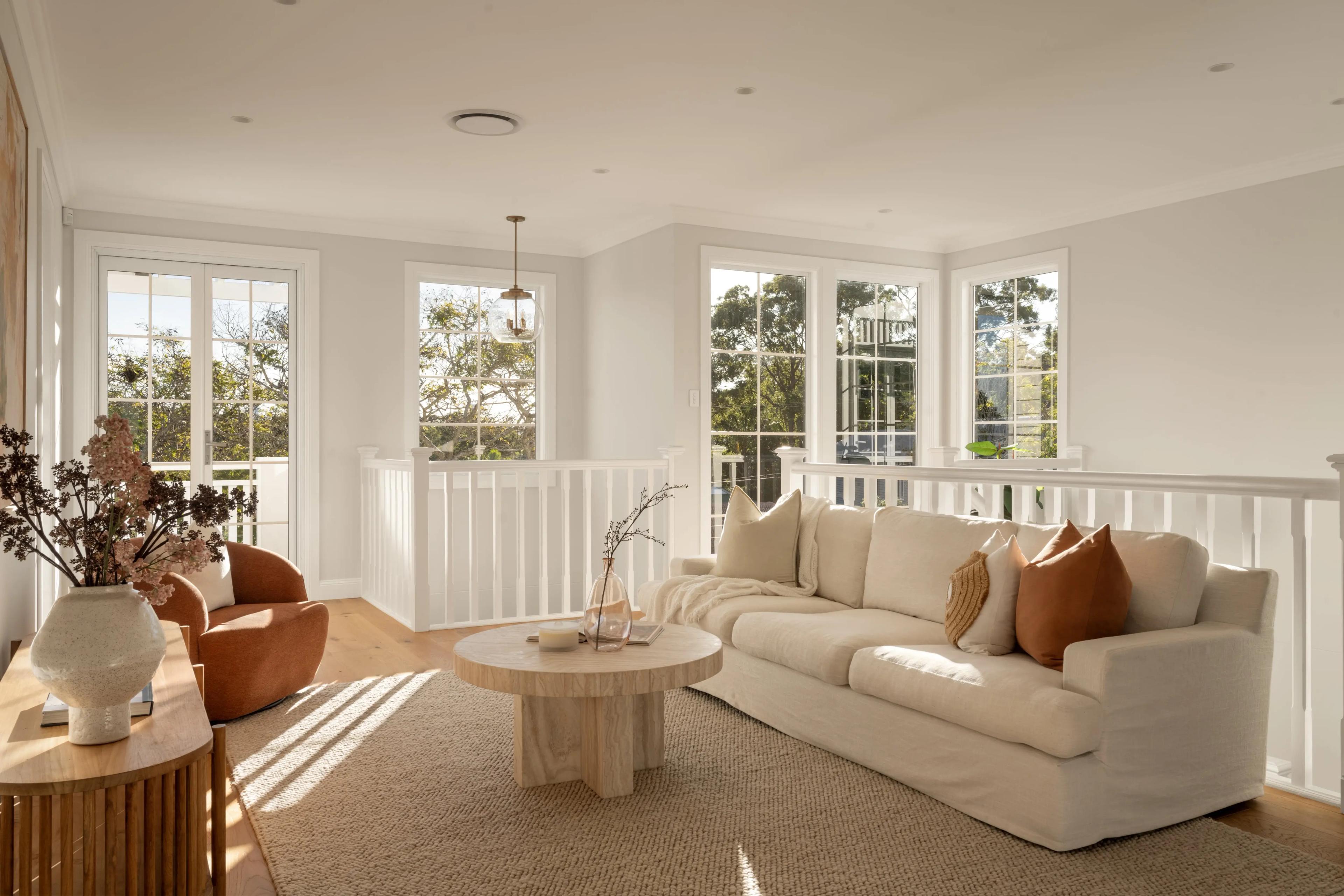 Upstairs living room with cream sofa and treetop views
