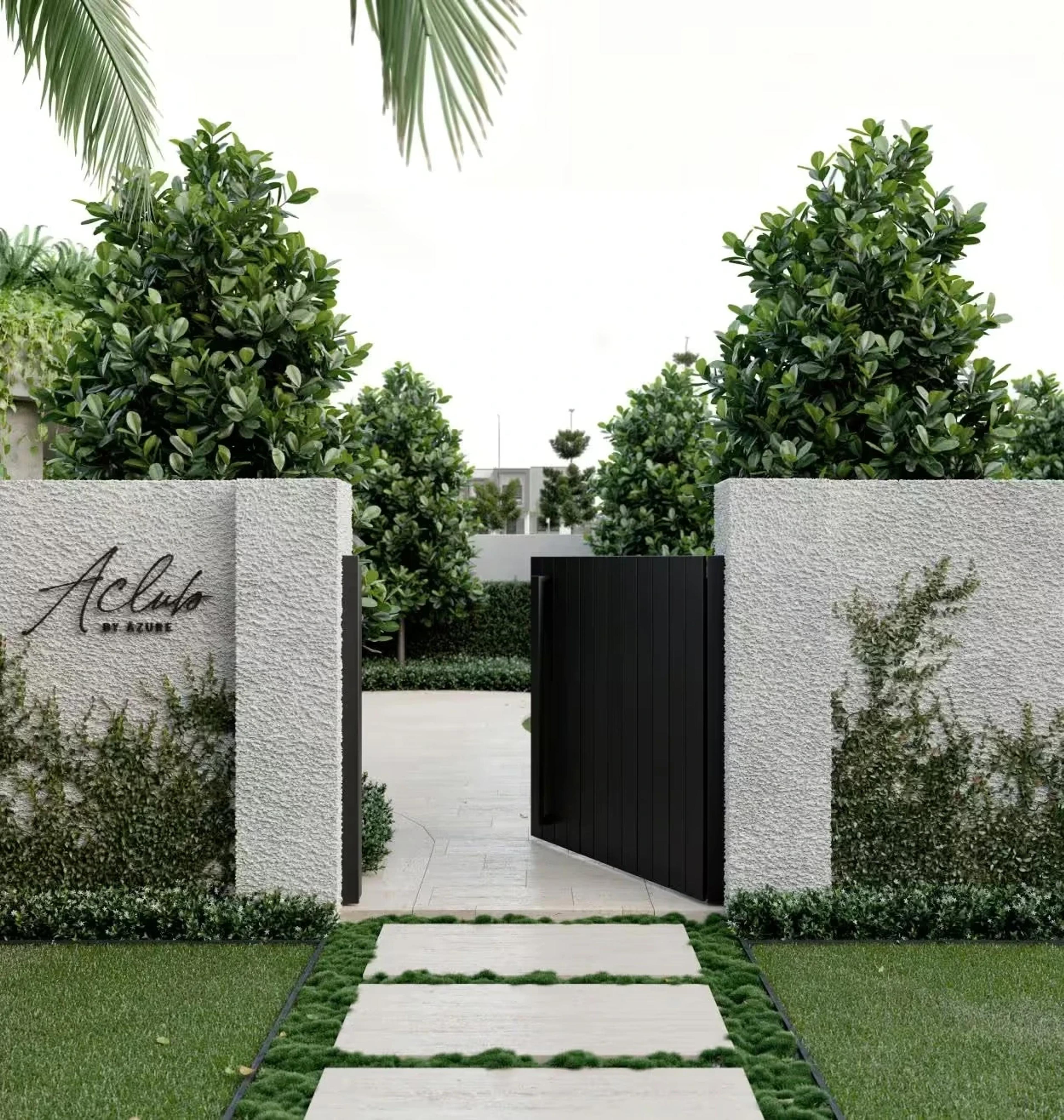 Landscaped entry path with open black gate and rendered walls