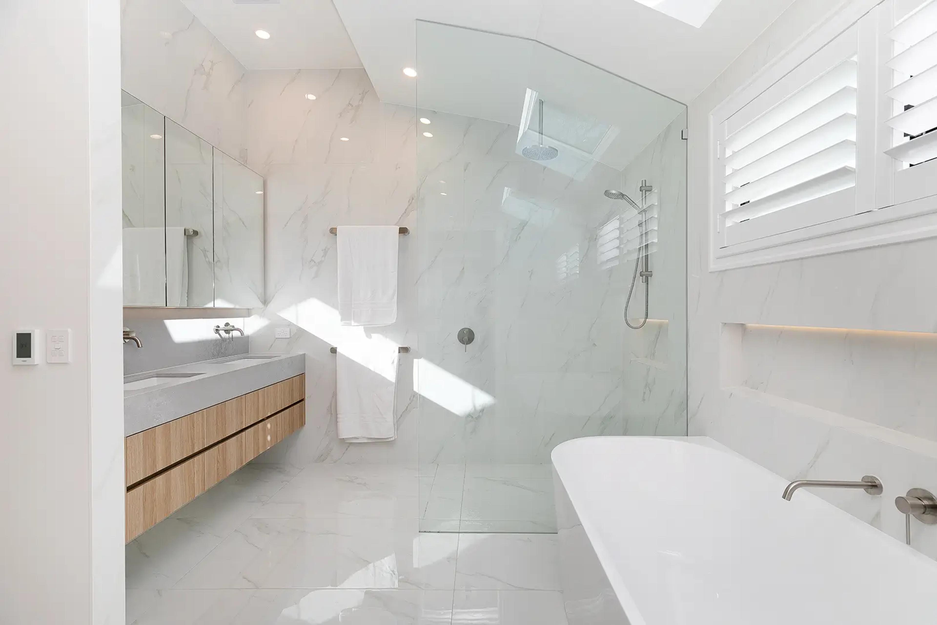 Marble bathroom with freestanding bath, walk in shower and twin vanity