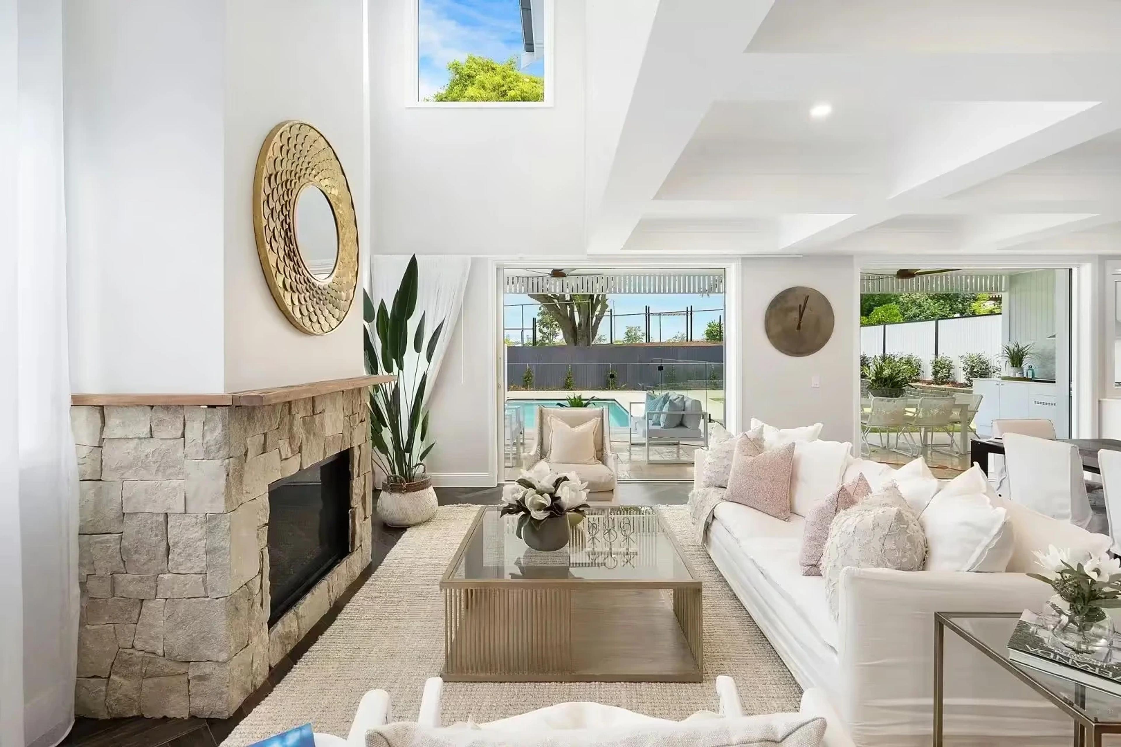 Living room with stone fireplace opening to pool terrace