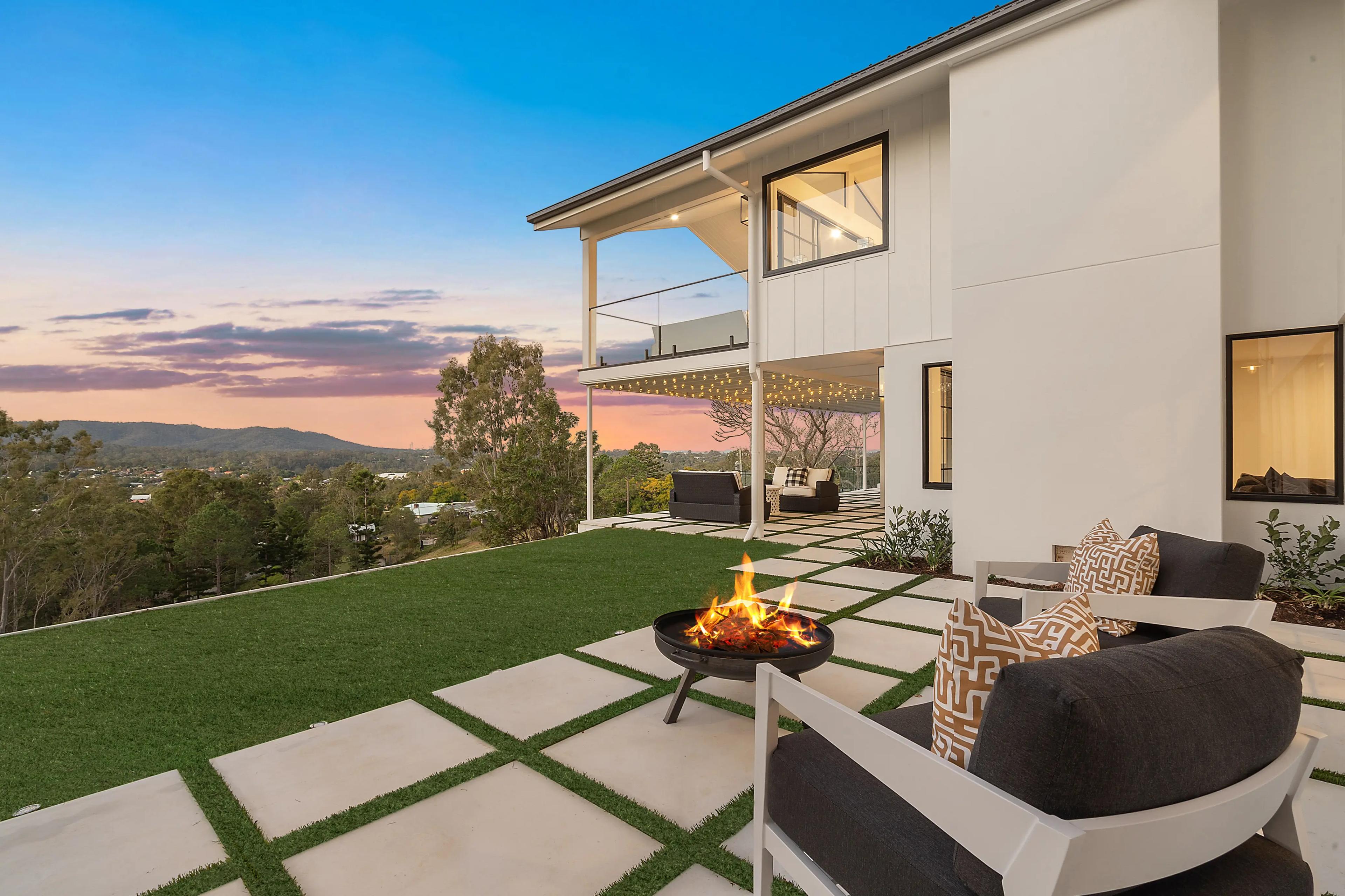 Paved terrace with firepit, armchairs and sunset valley views.