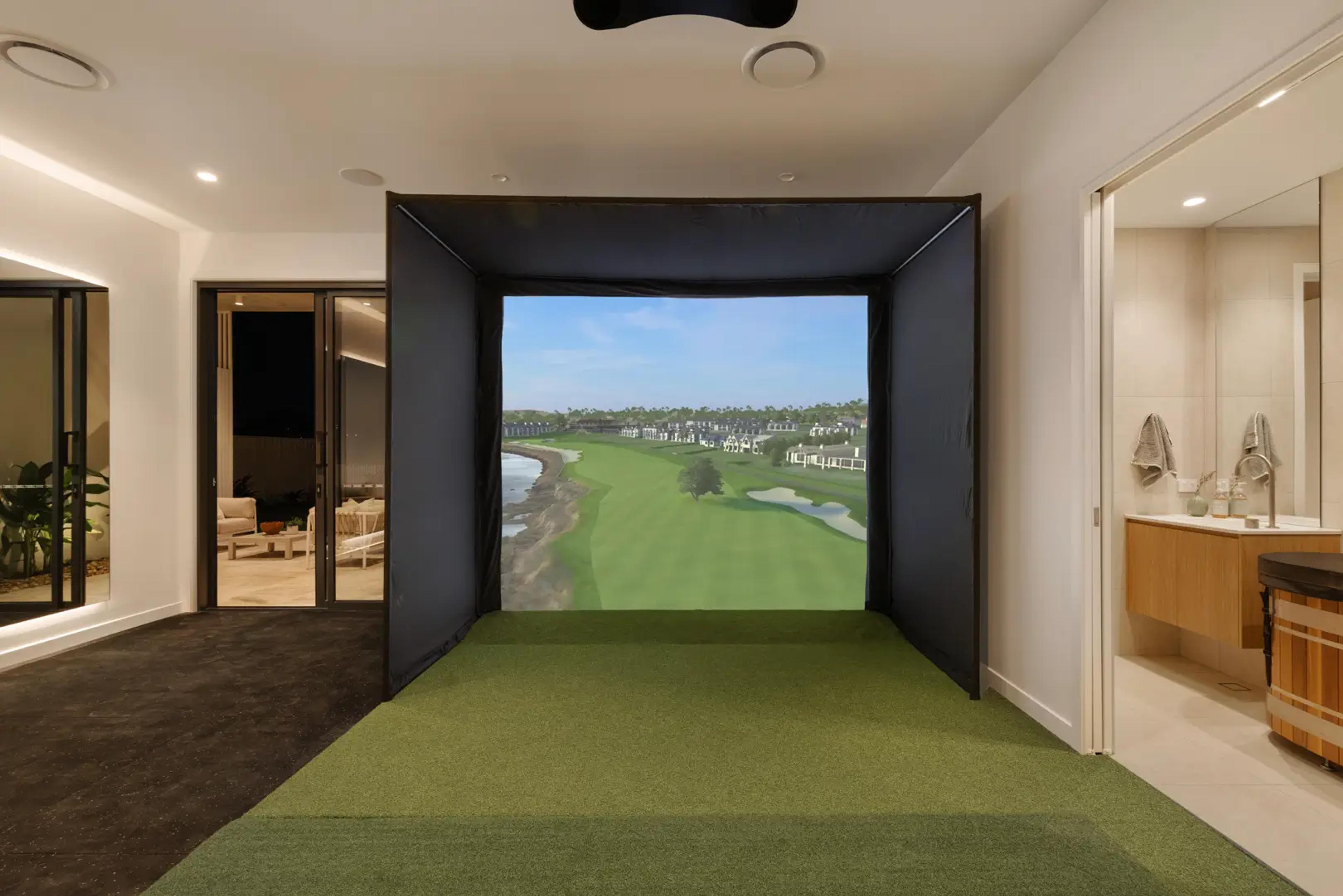 Golf simulator alcove beside bathroom with garden view