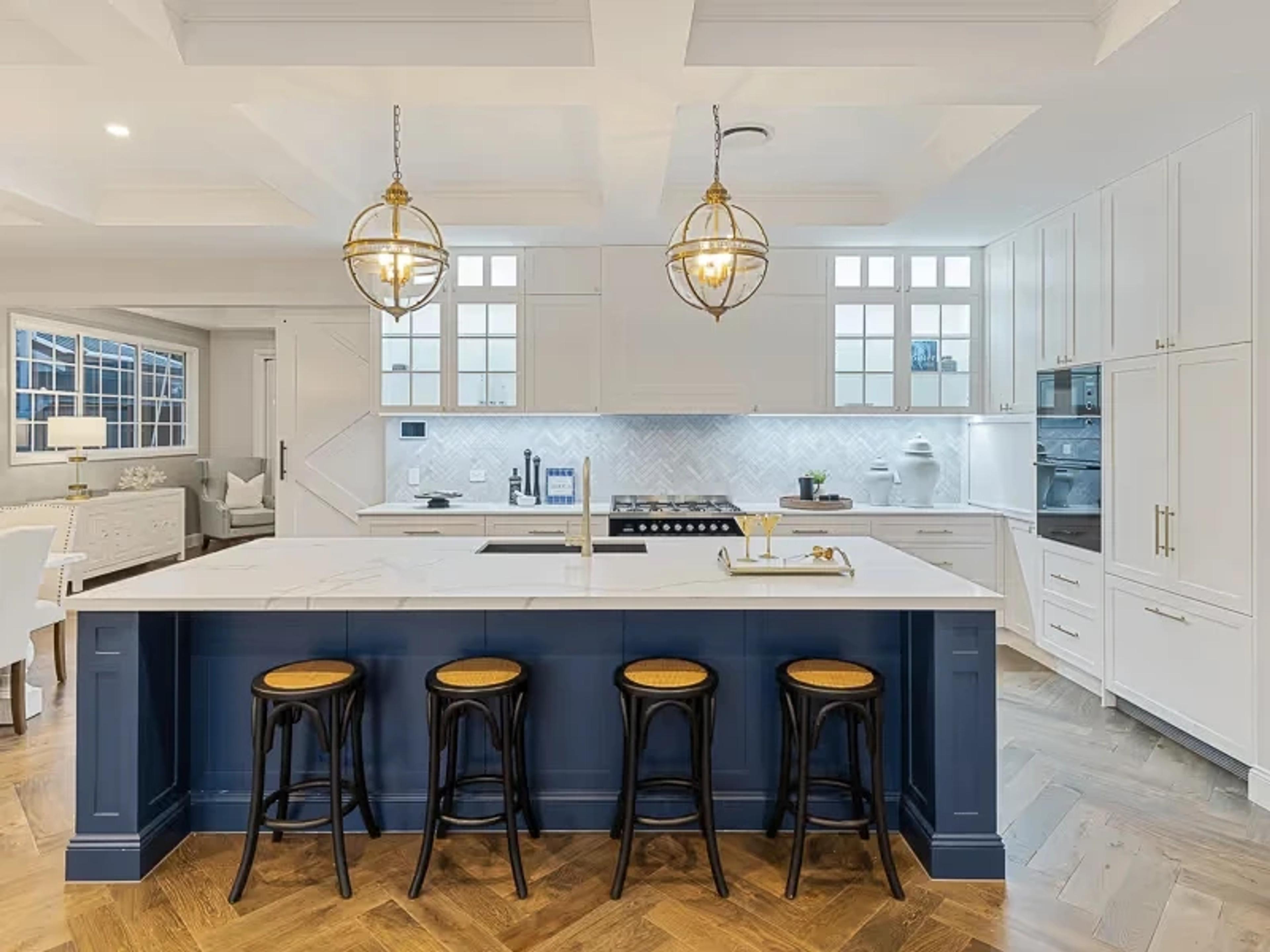 White kitchen with navy island and pendant lights