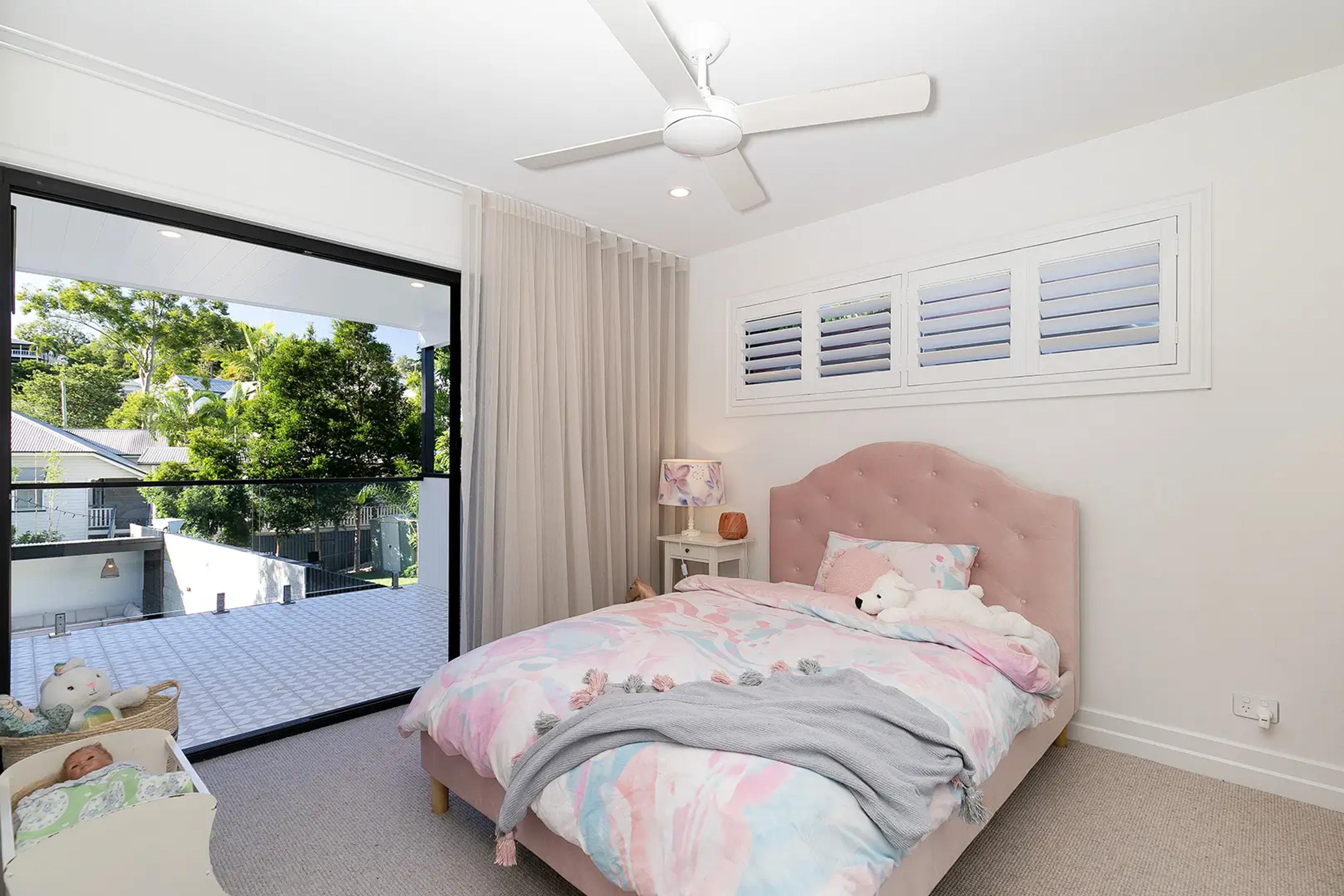 Children's bedroom with pink bed and balcony access