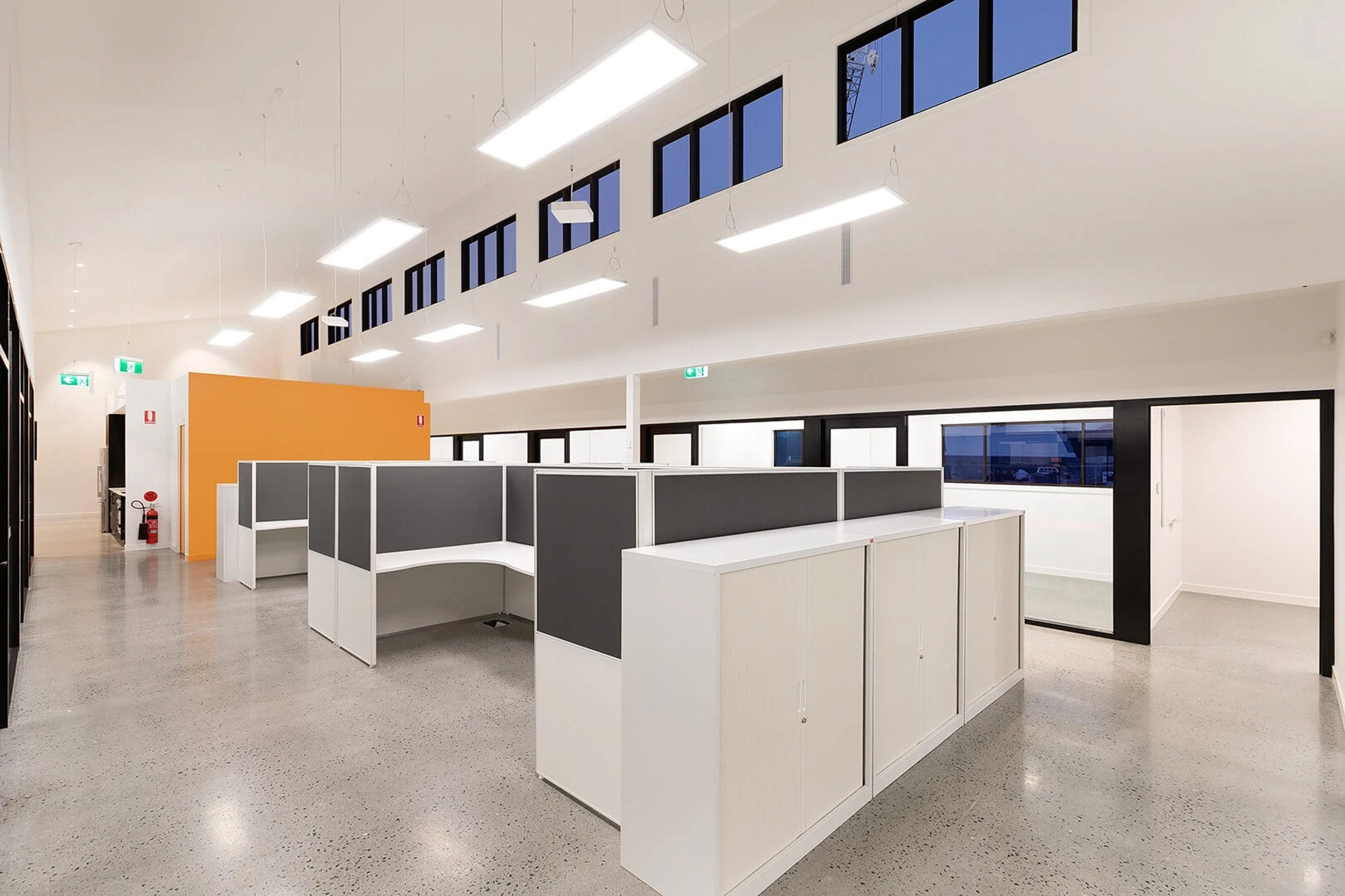 Office workstations with orange partition and polished concrete floor
