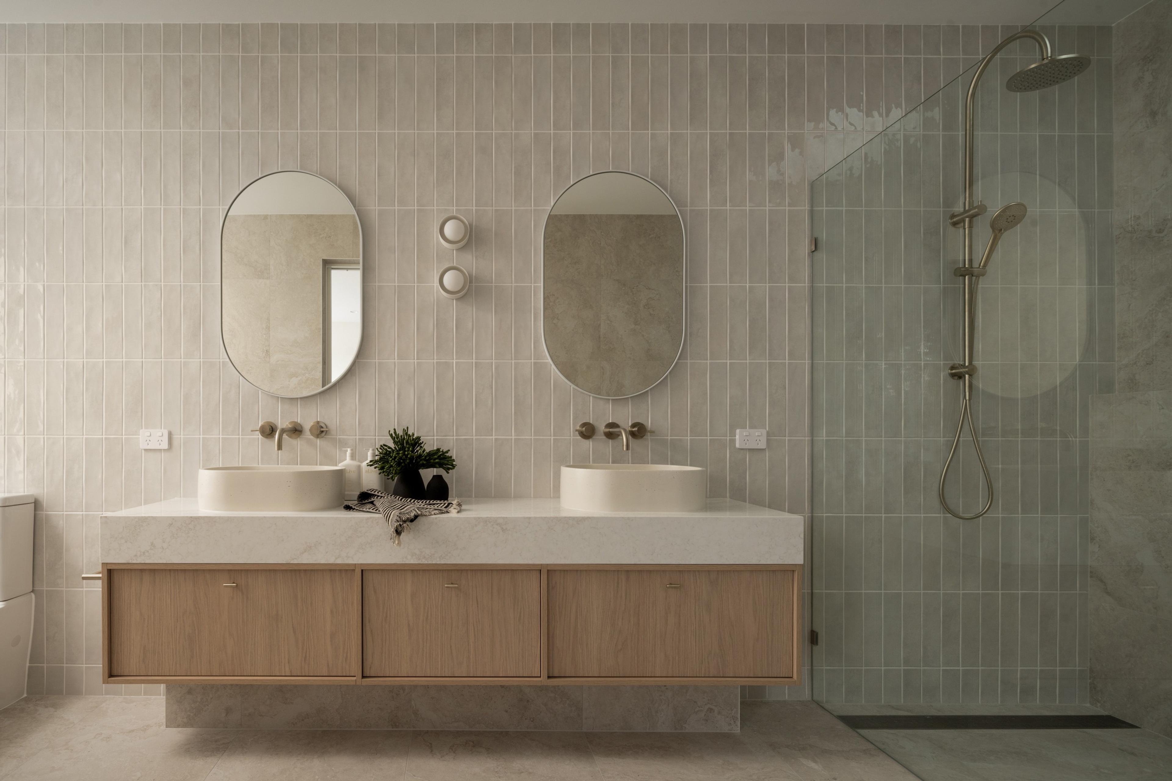 Bathroom with double vanity, oval mirrors and walk in shower