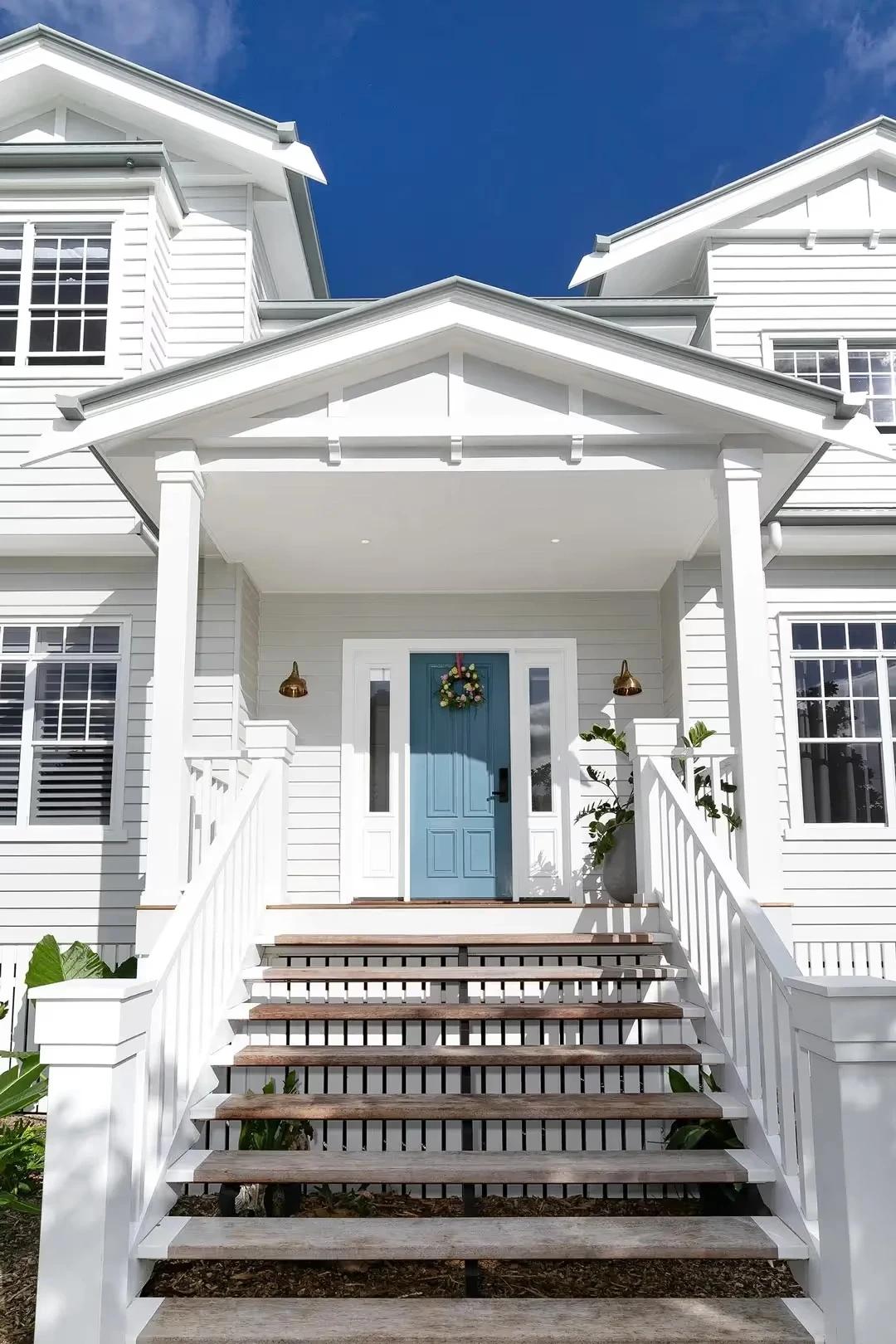 Front entry porch with blue timber door and steps