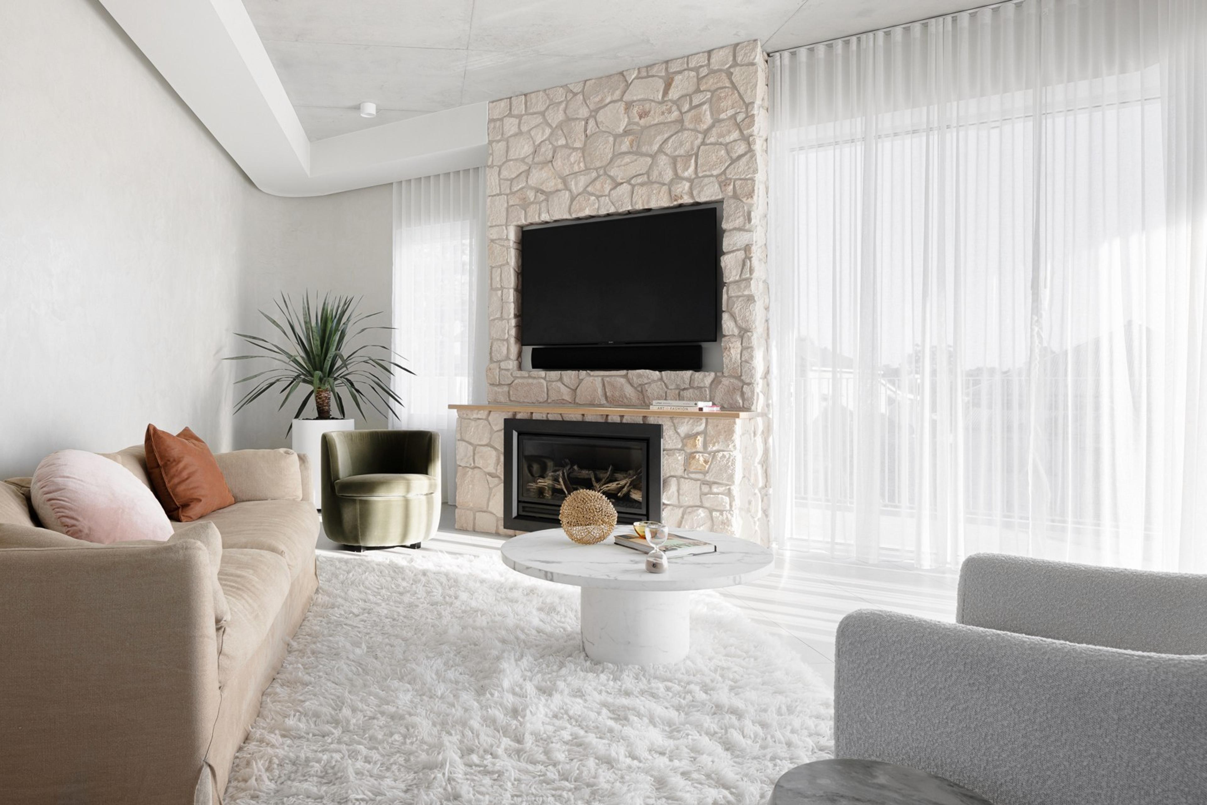 Living room with stone fireplace and neutral lounge seating