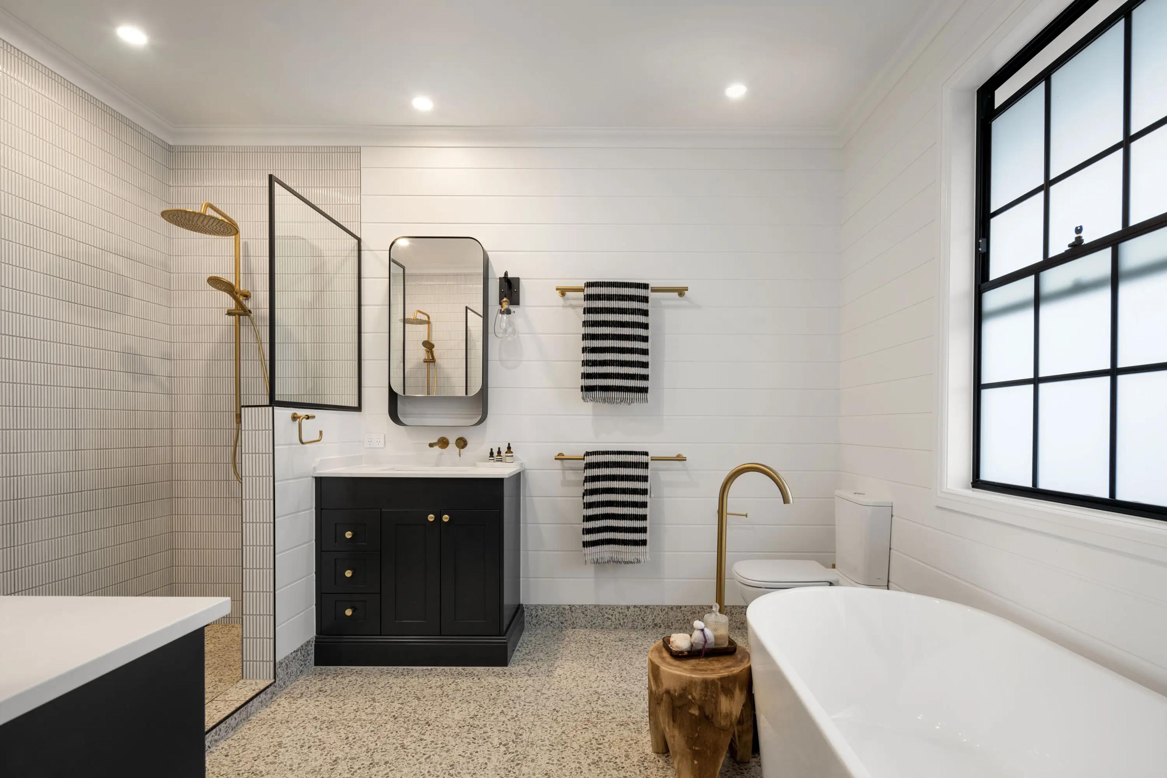 Bathroom with walk in shower, freestanding bath and black vanity