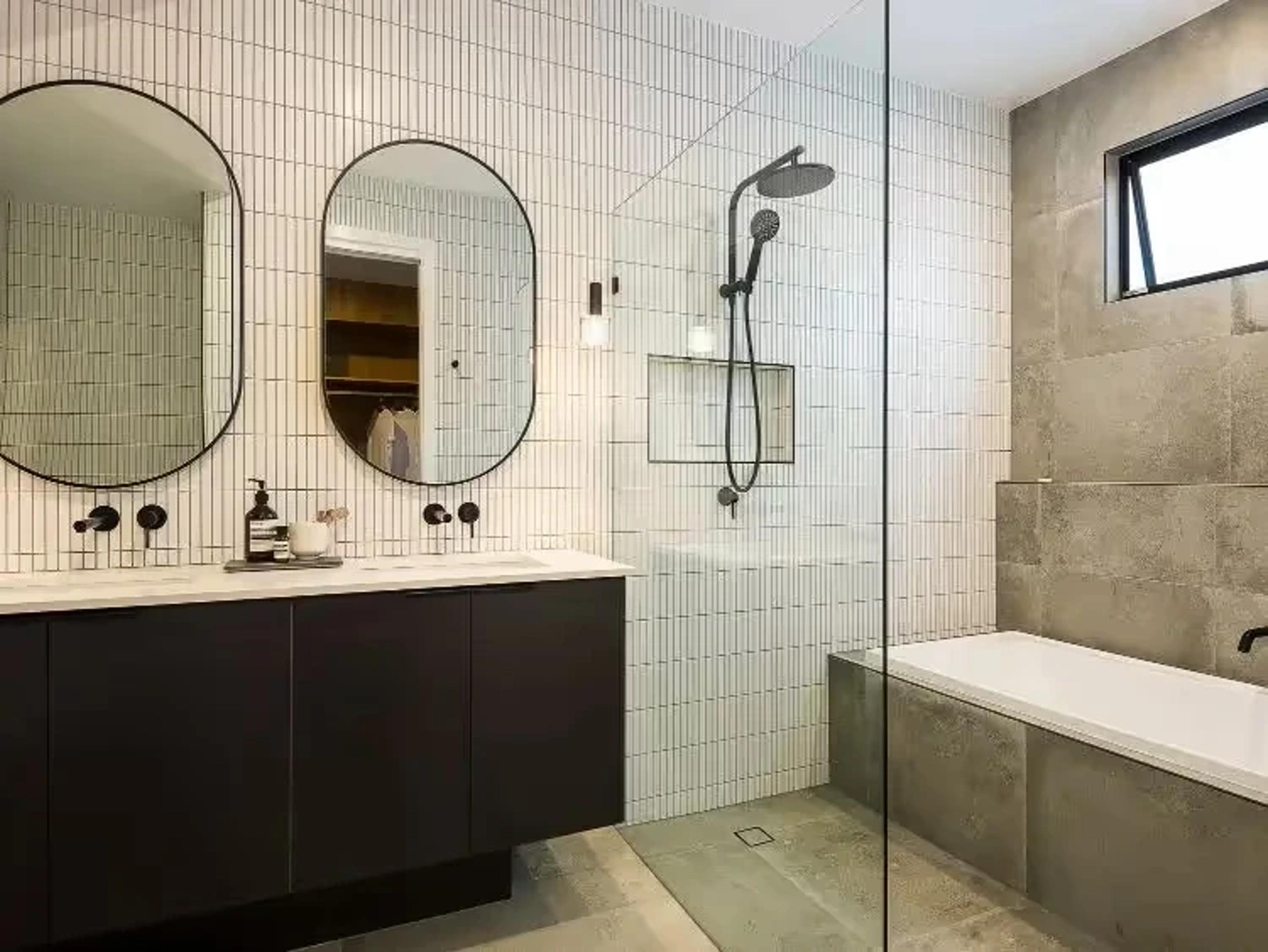 Bathroom with twin oval mirrors, walk in shower and bath