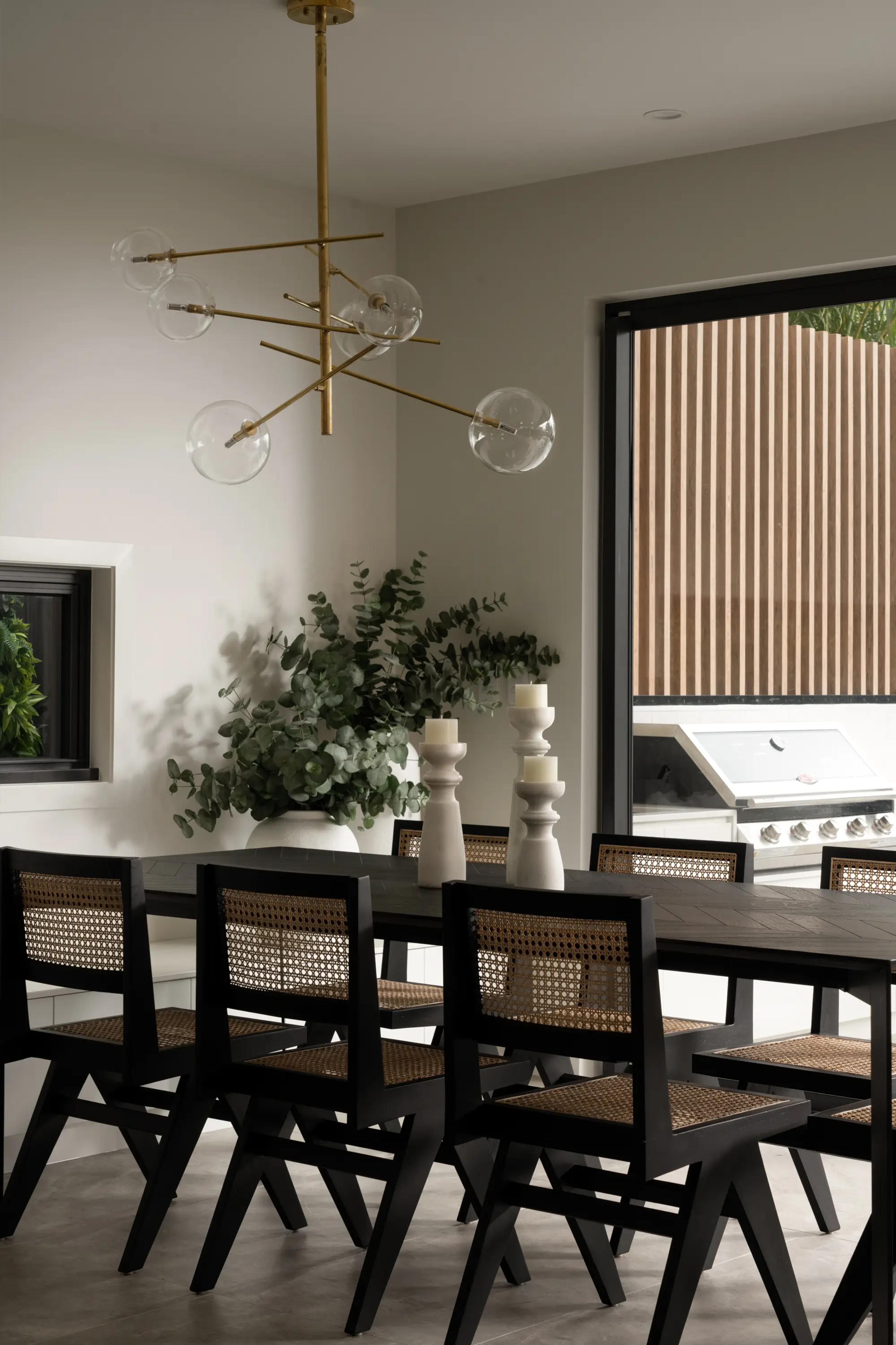 Dining area with brass pendant and cane chairs