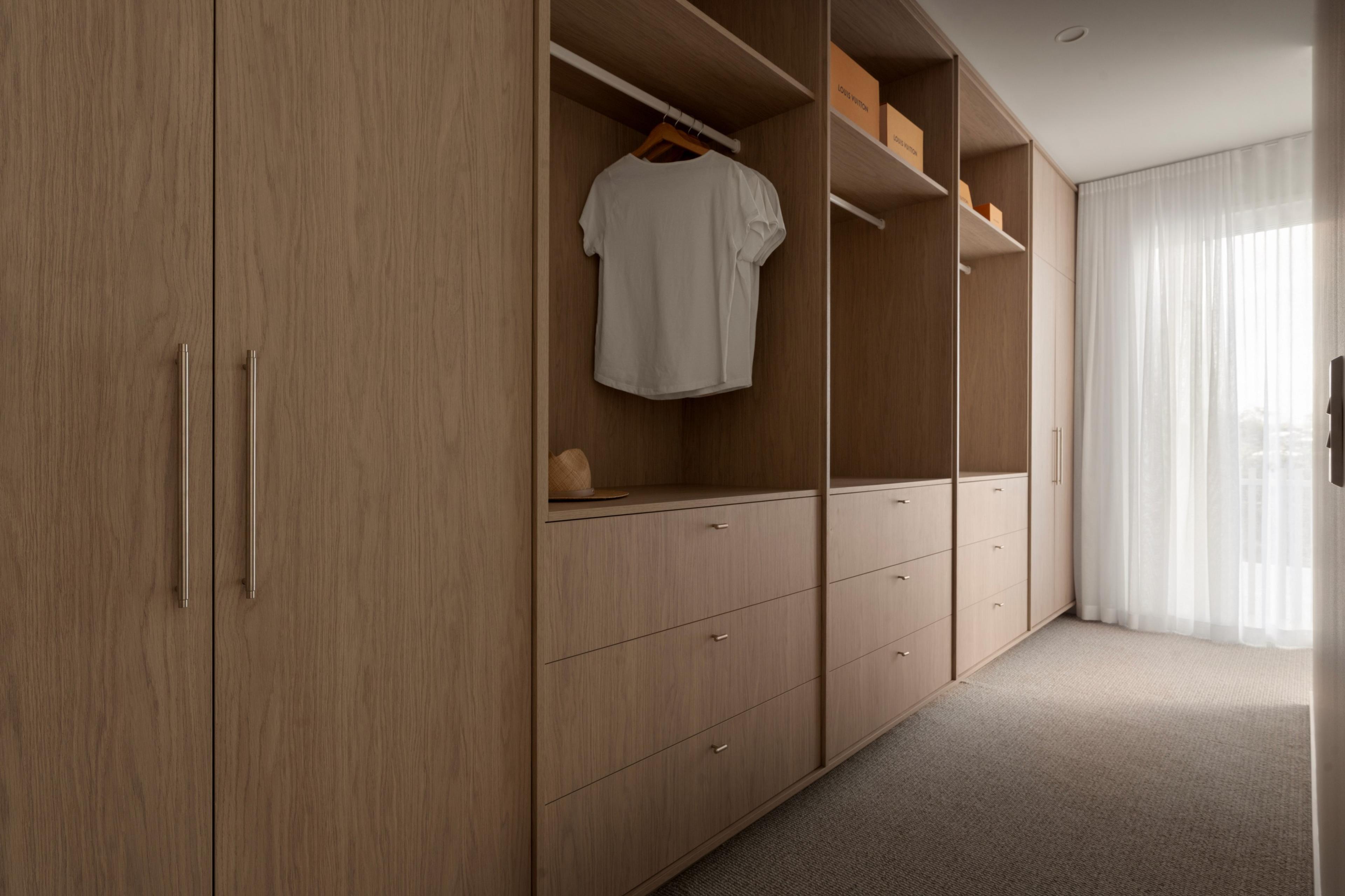 Walk in wardrobe with timber cabinetry and drawers