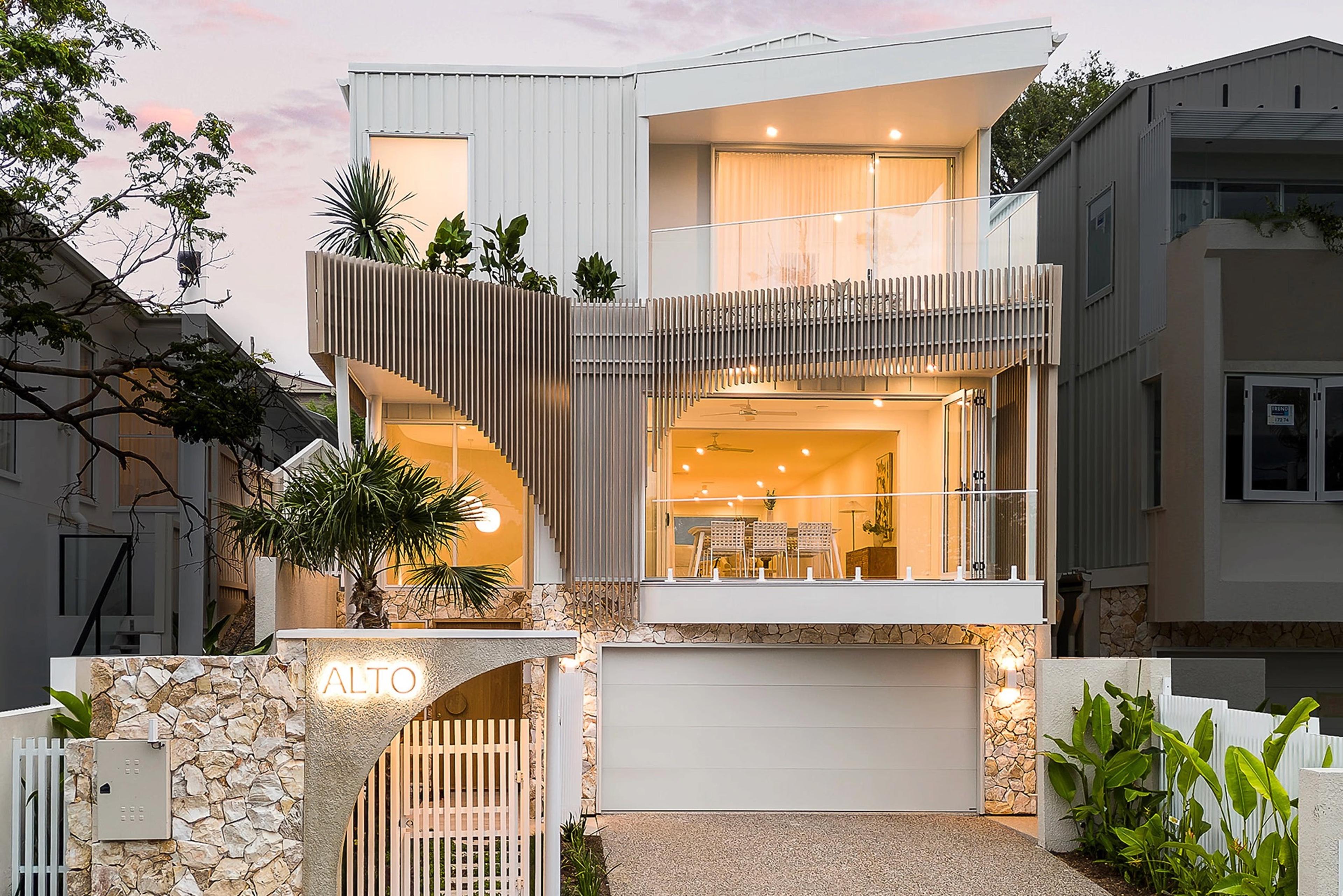 Two-storey street facade at dusk with garage