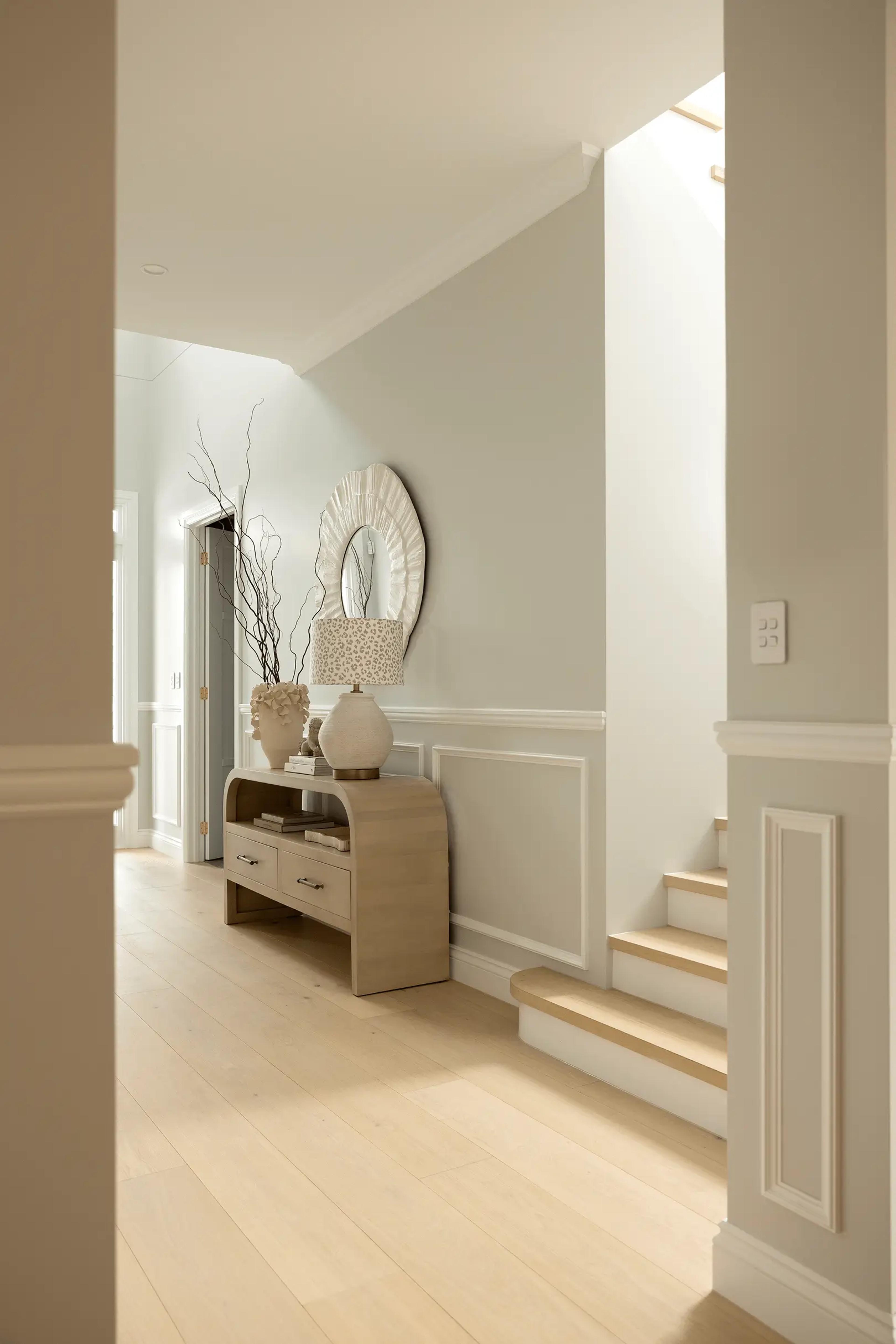 Entry foyer with panelled walls and timber staircase