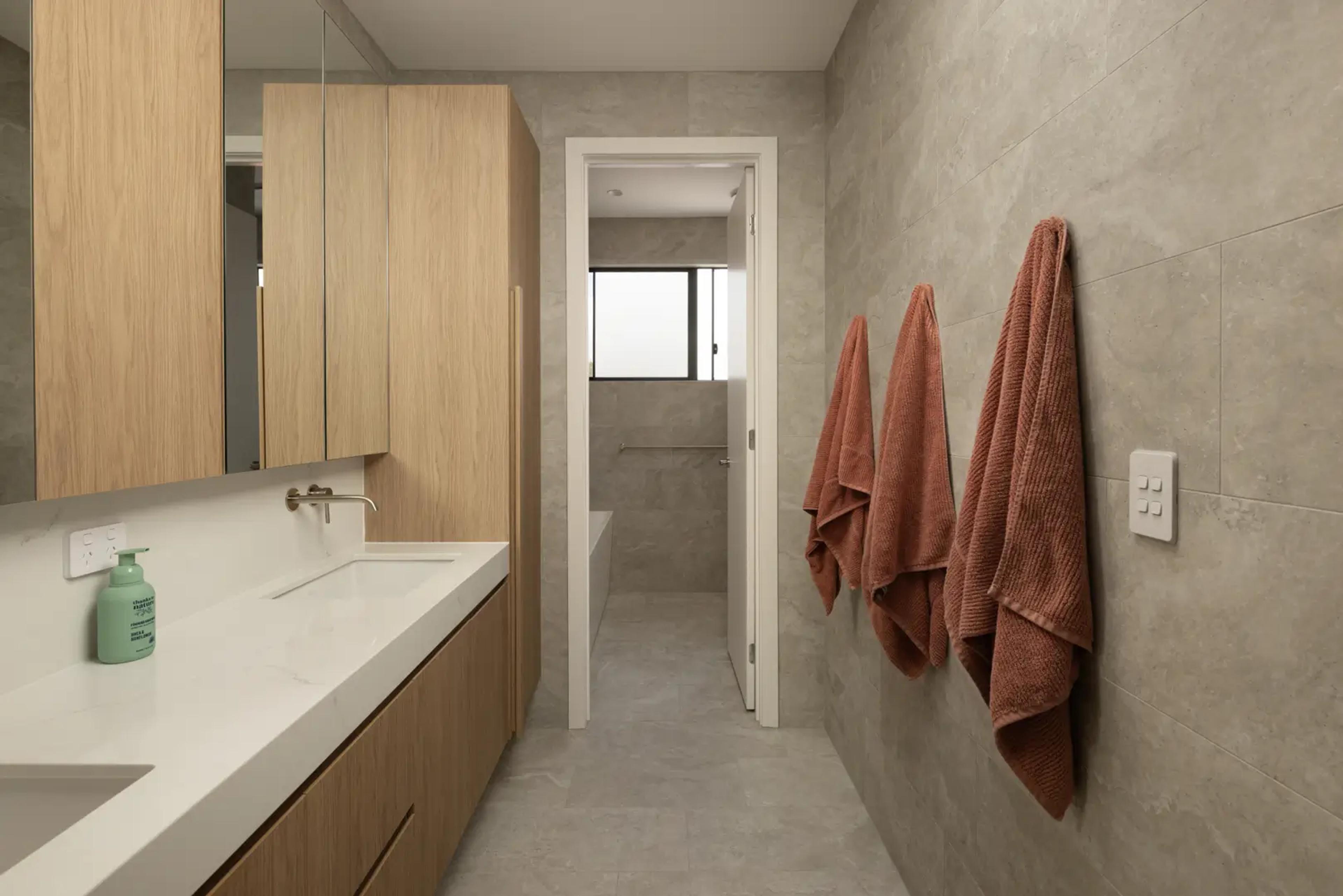 Bathroom vanity with mirror and towels on wall