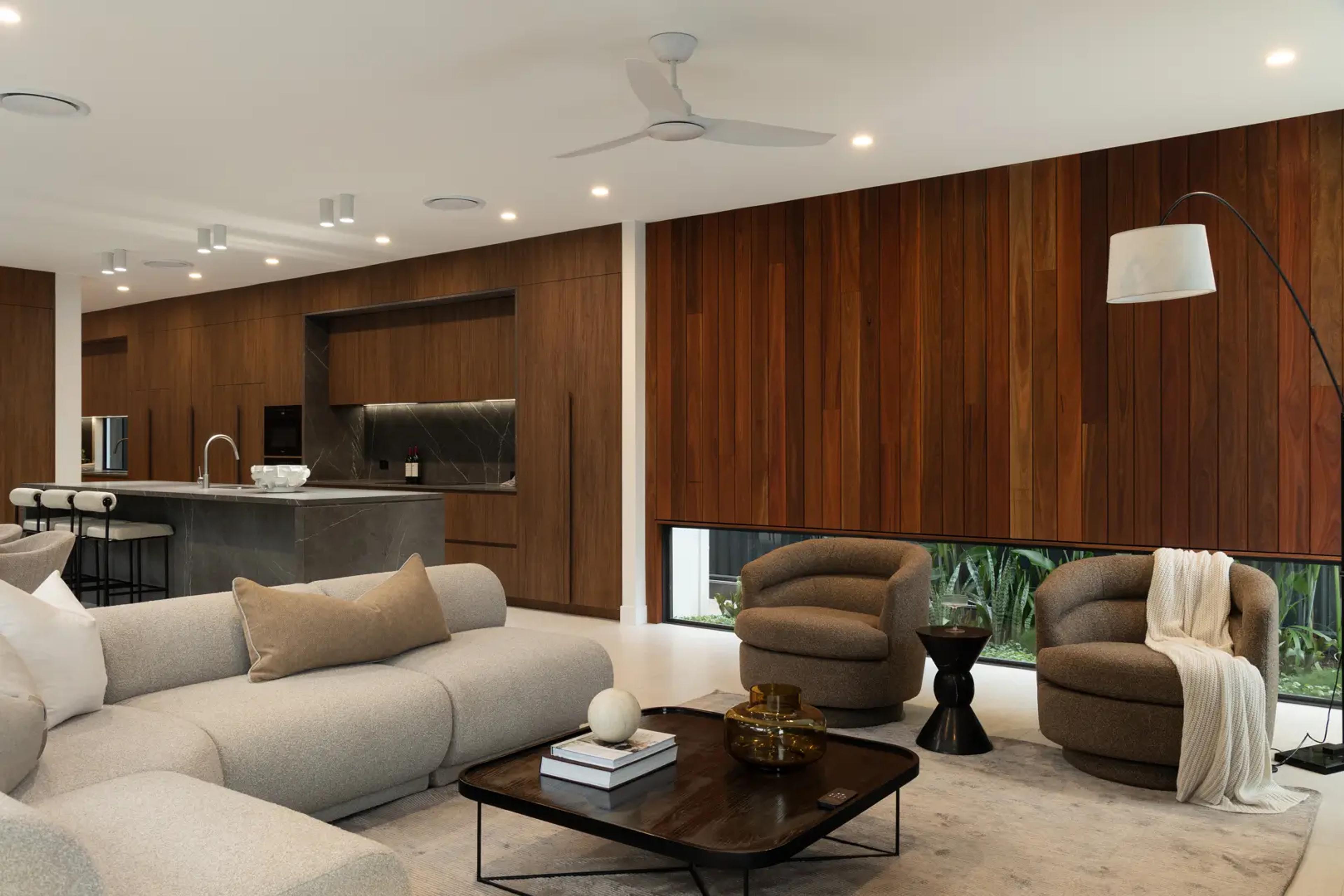 Living room with timber walls and grey sofa