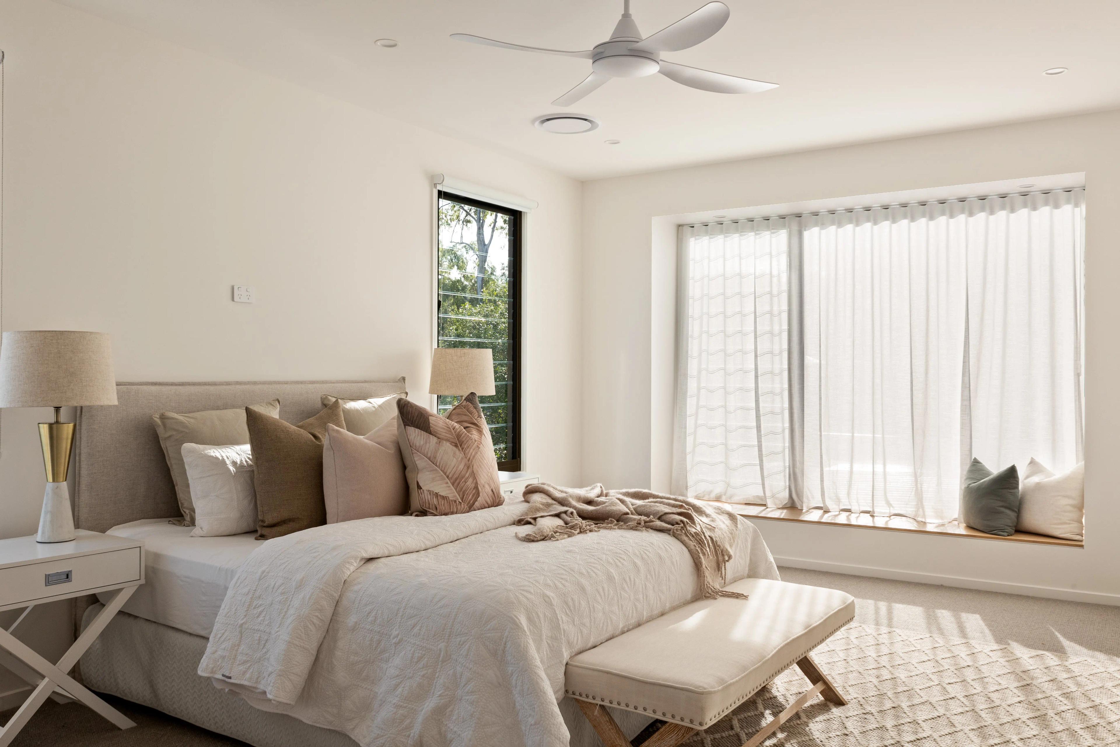 Main bedroom with upholstered bed and window seat