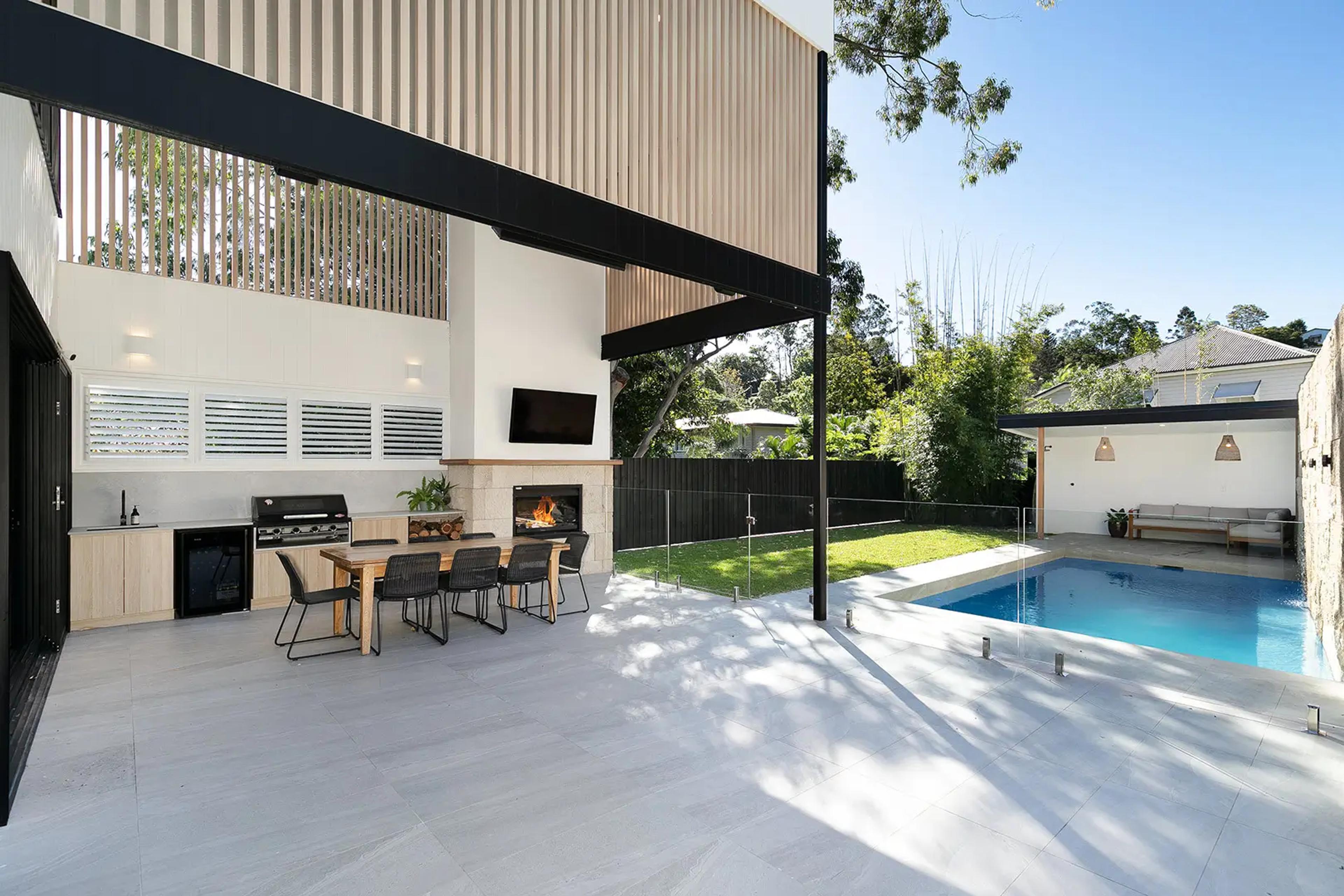 Backyard with swimming pool, alfresco kitchen and glass pool fence