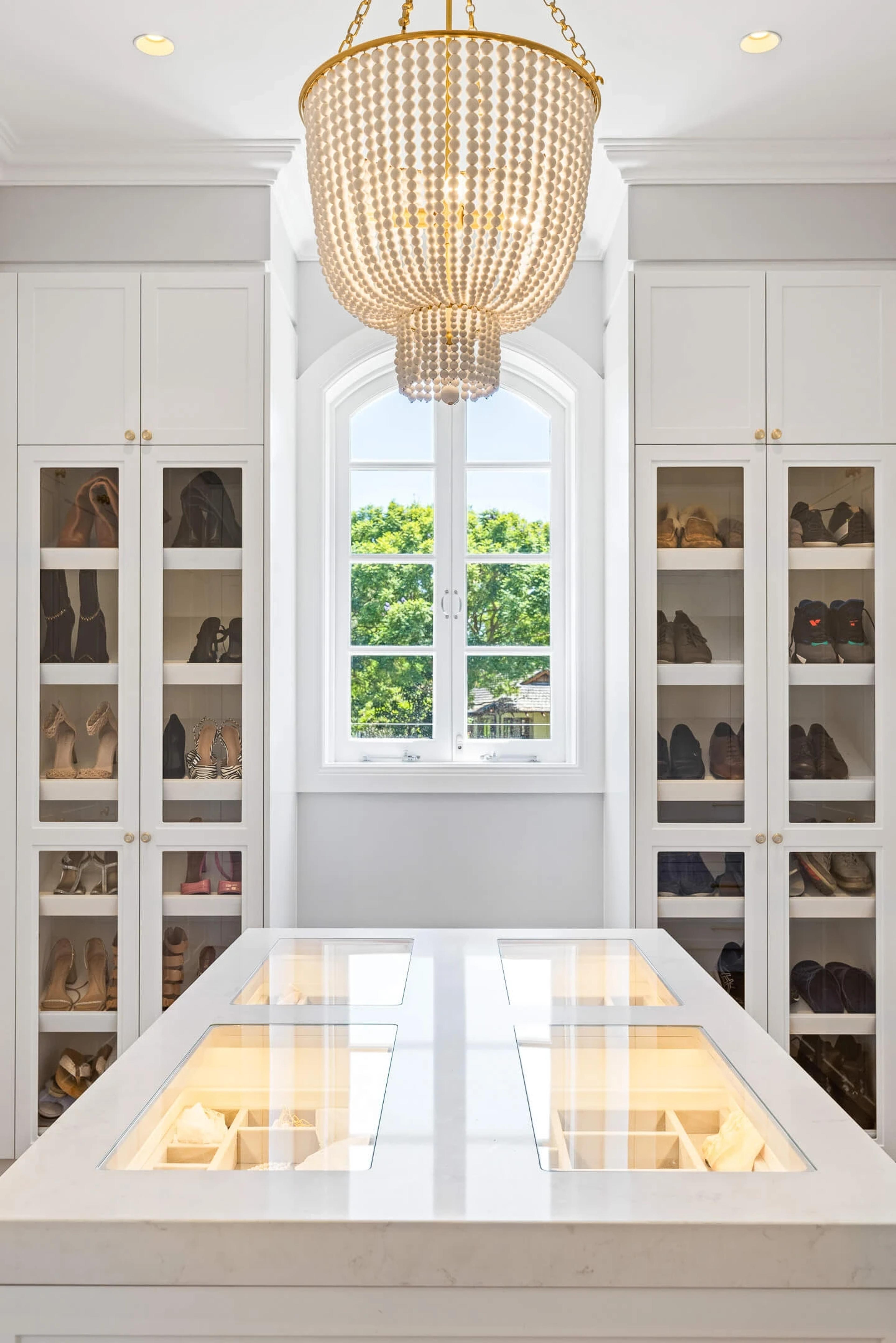 Walk-in wardrobe with glass shoe cabinets and display island