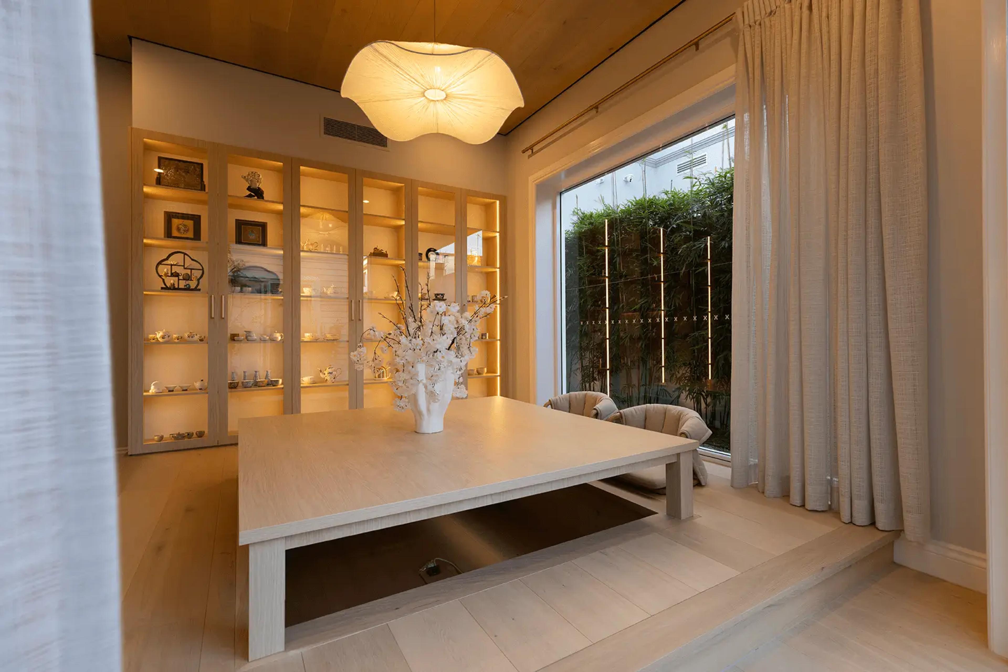 Tea room with lit display cabinetry and courtyard view