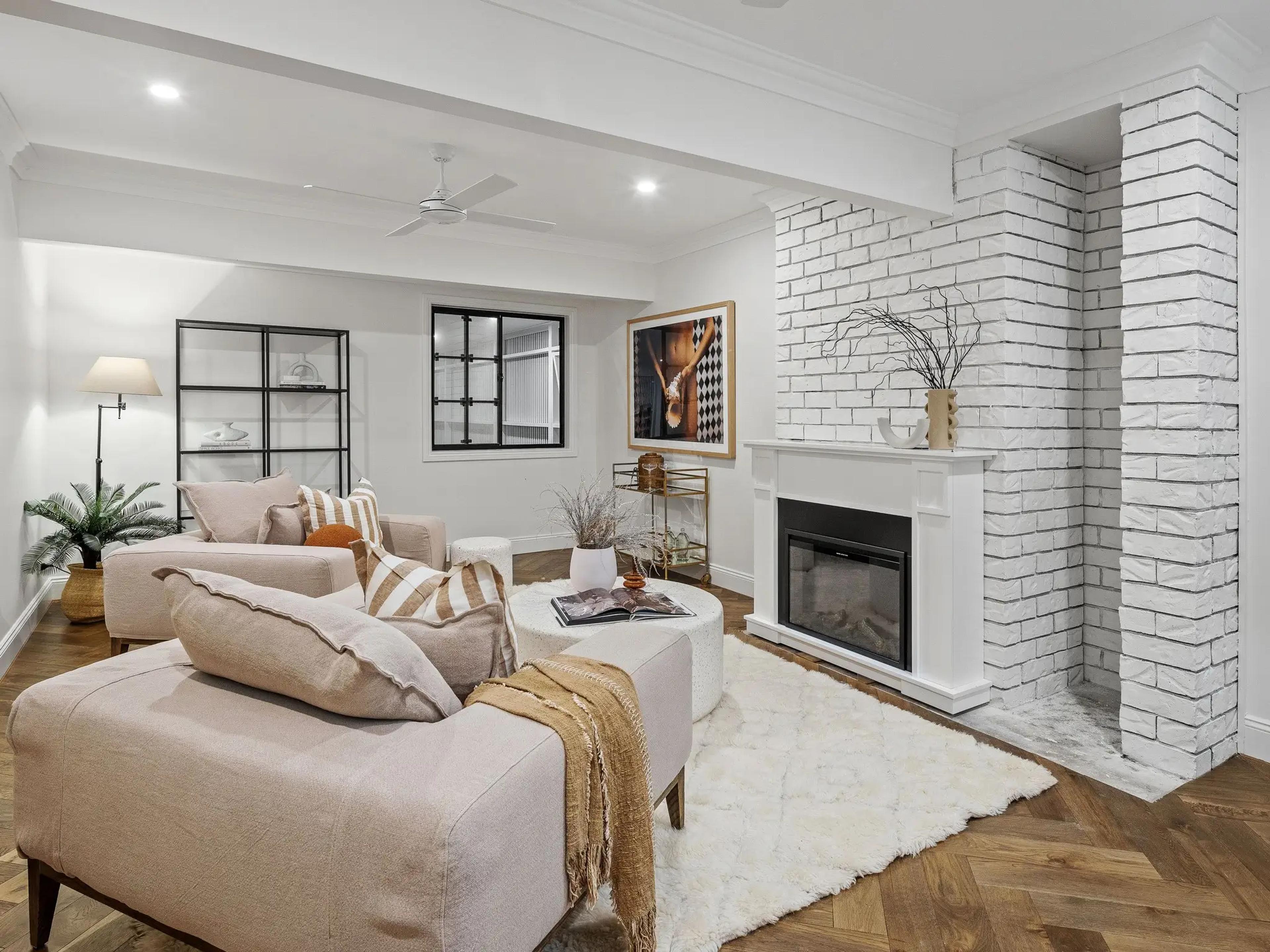 Sitting room with white brick fireplace and lounges