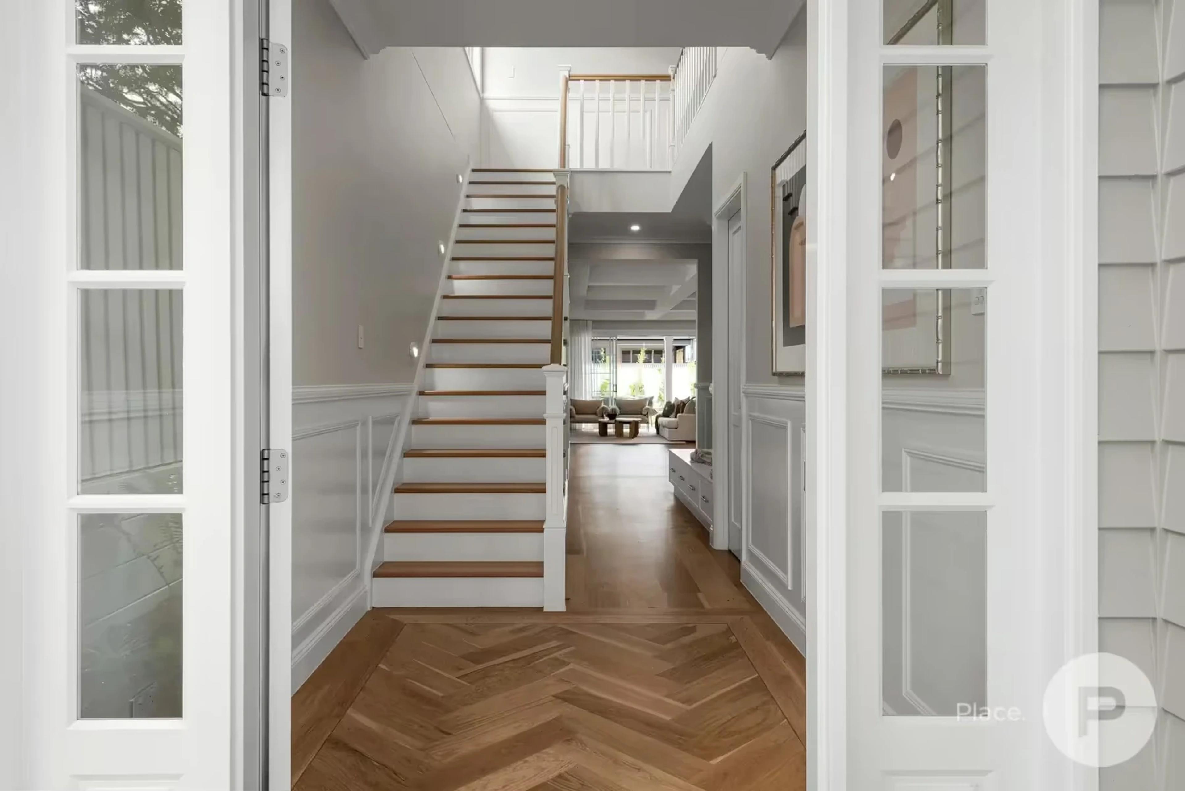 Entry foyer with timber staircase and herringbone floor