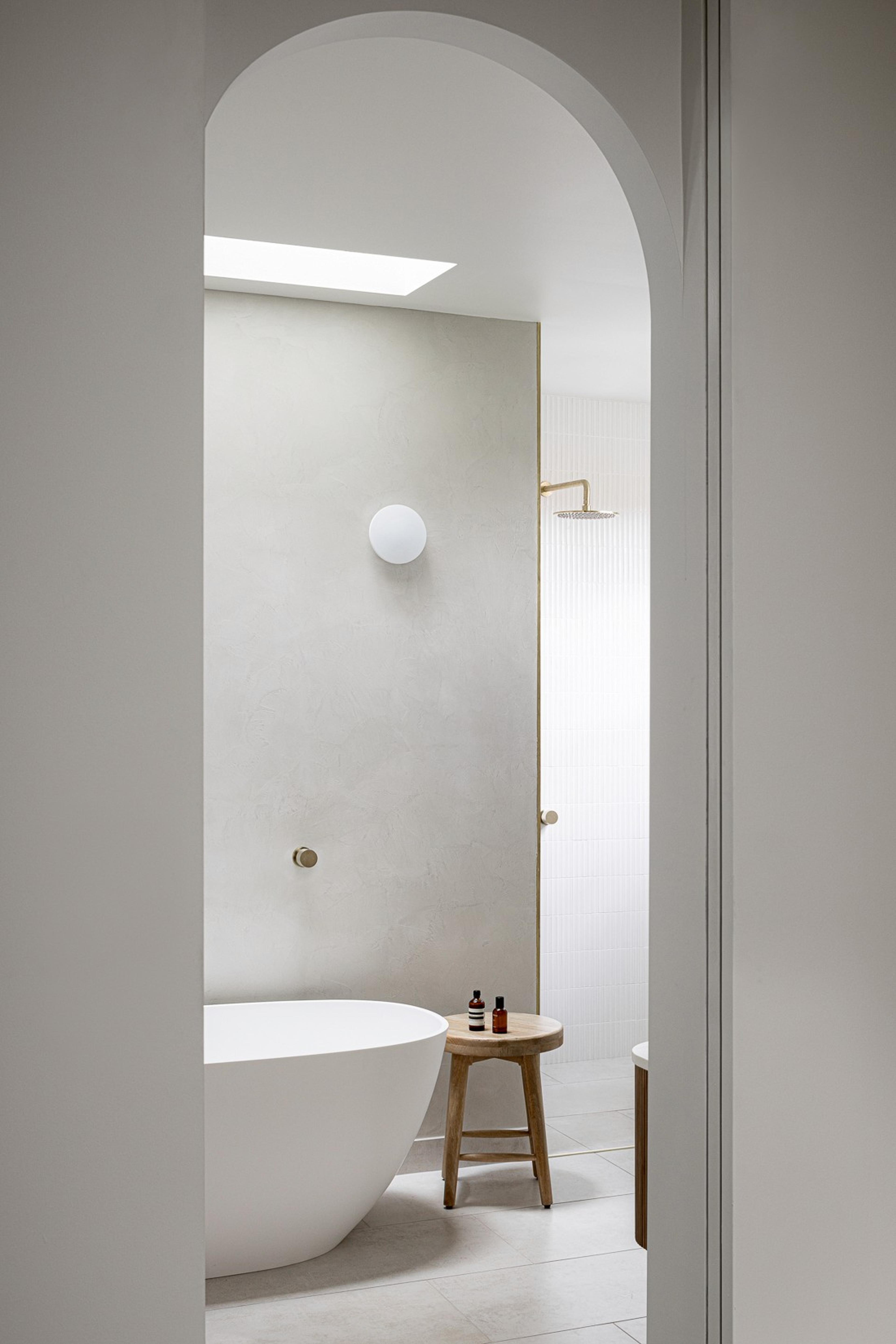 Bathroom with freestanding tub viewed through arched opening