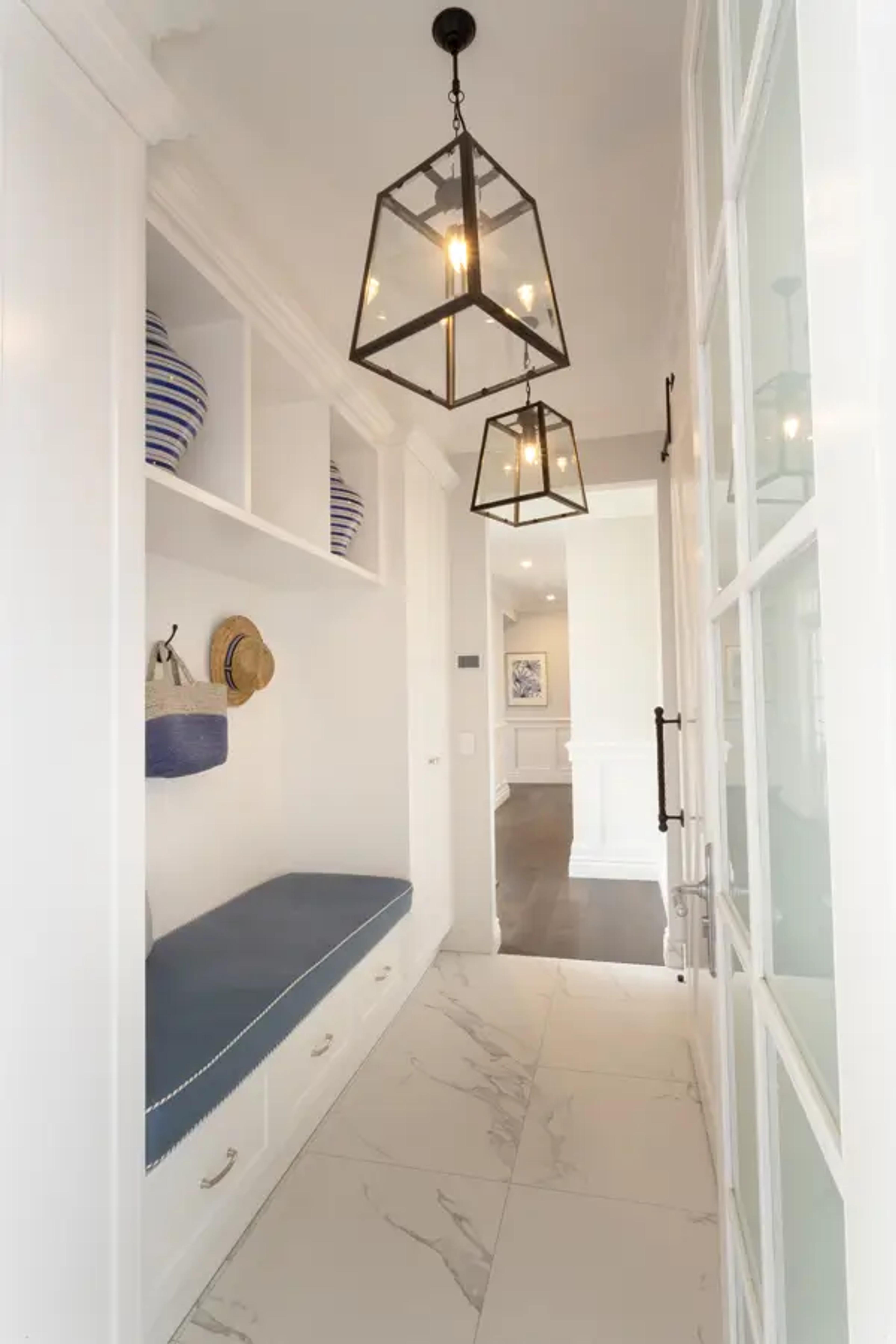 Mudroom hallway with built in bench and lantern lights