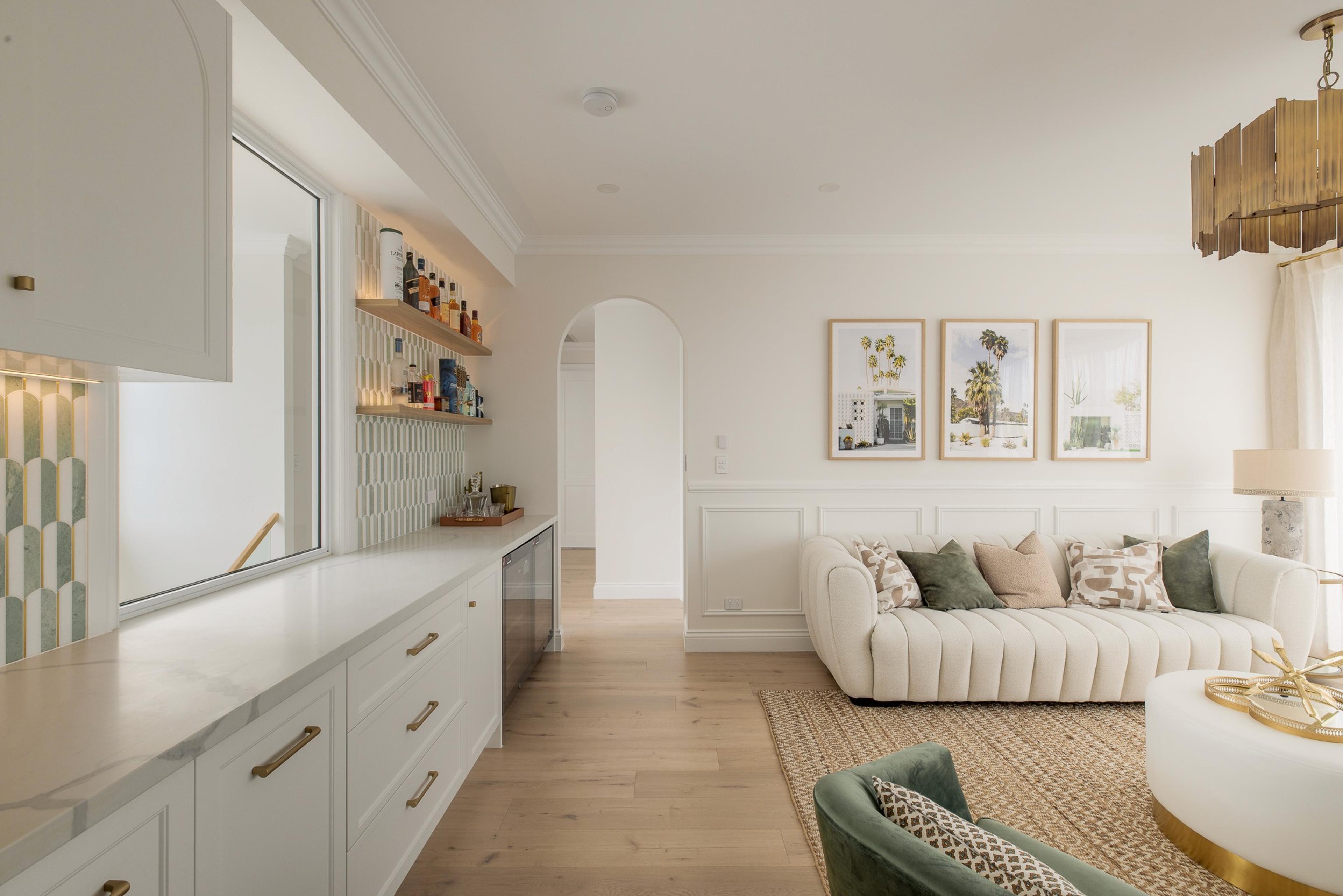 Living room with white sofa, bar cabinetry and framed prints
