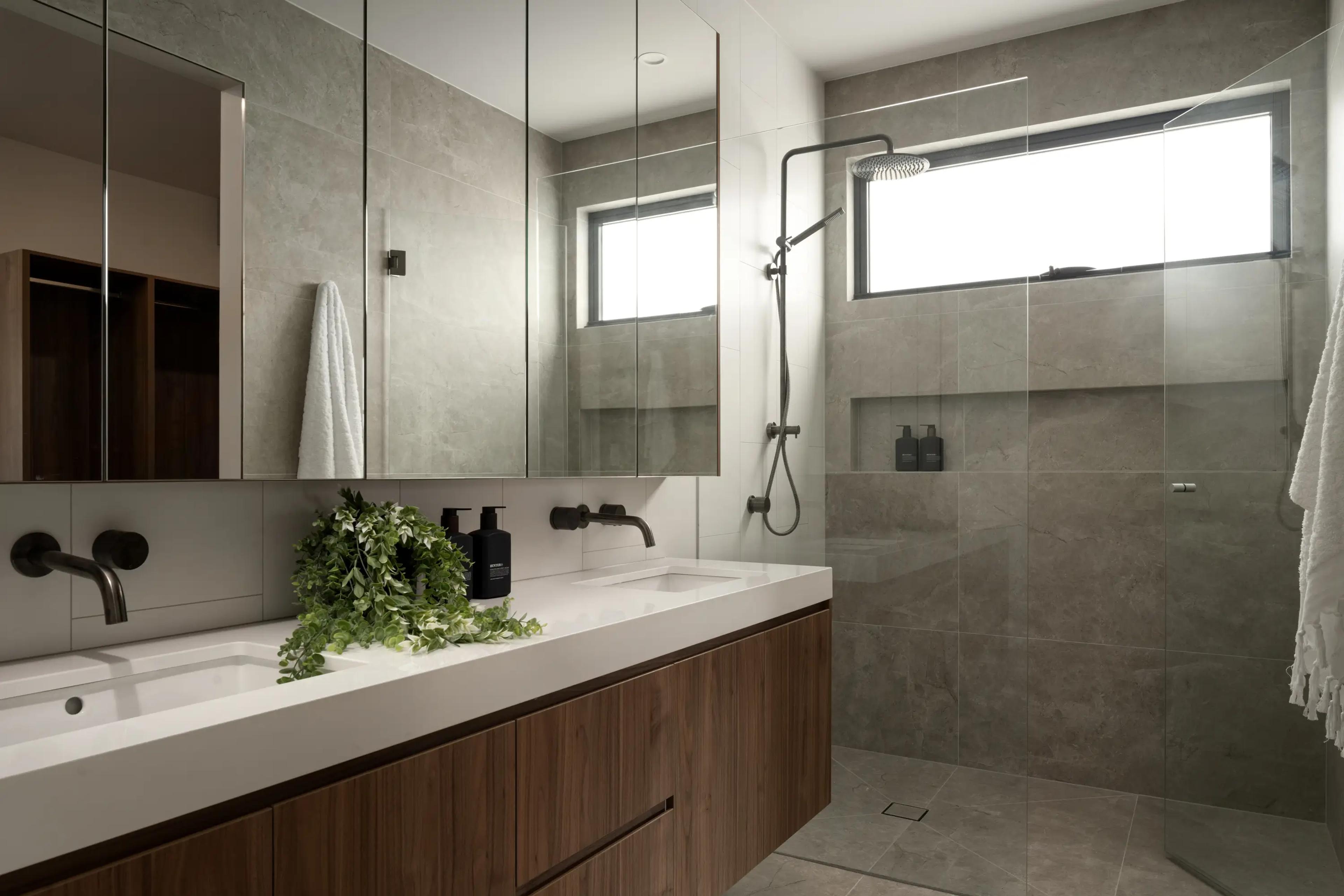 Bathroom with double vanity, mirrors and walk in shower