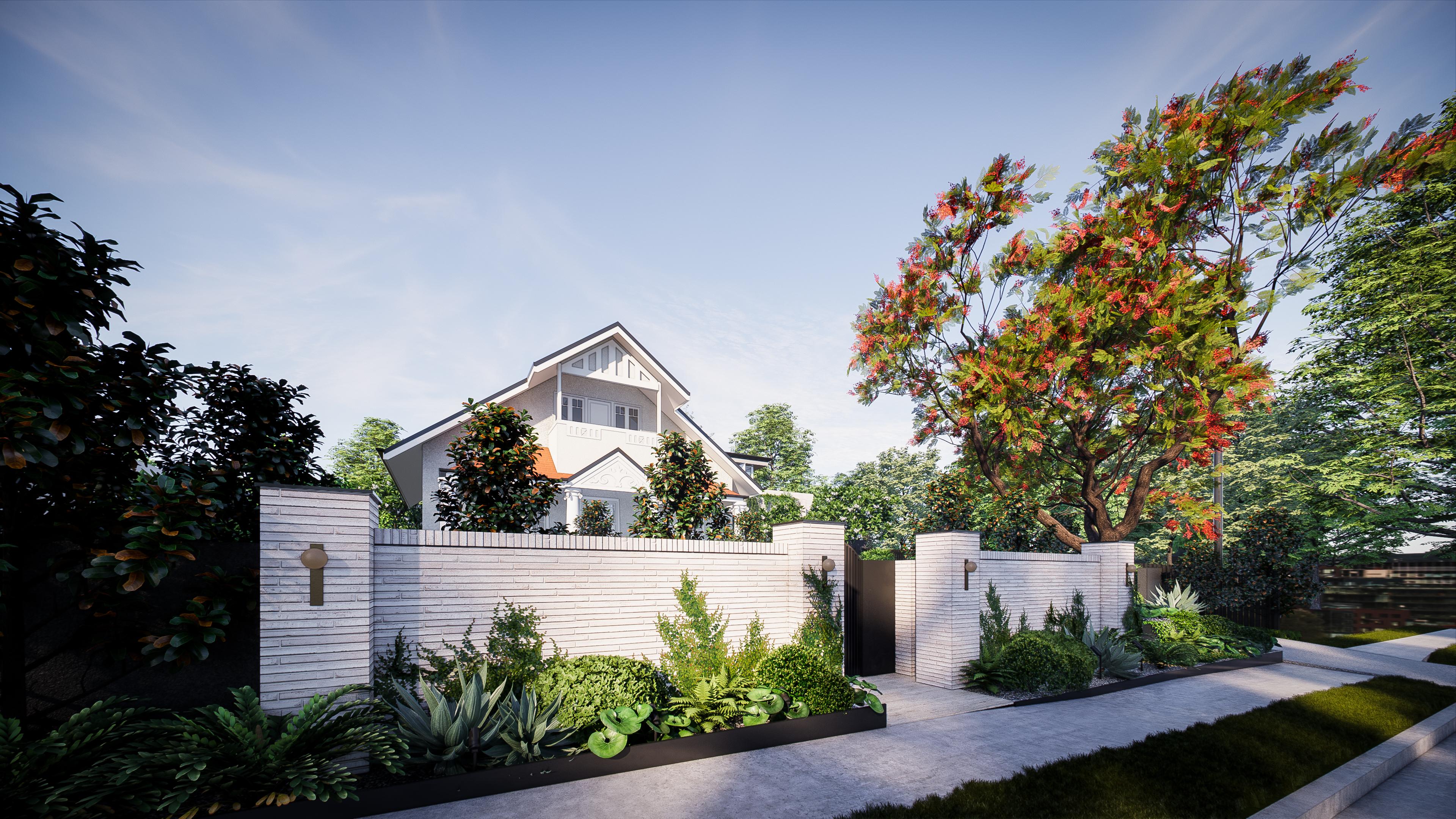 Angled street view of the gabled facade rising above a white brick boundary wall with layered subtropical garden beds