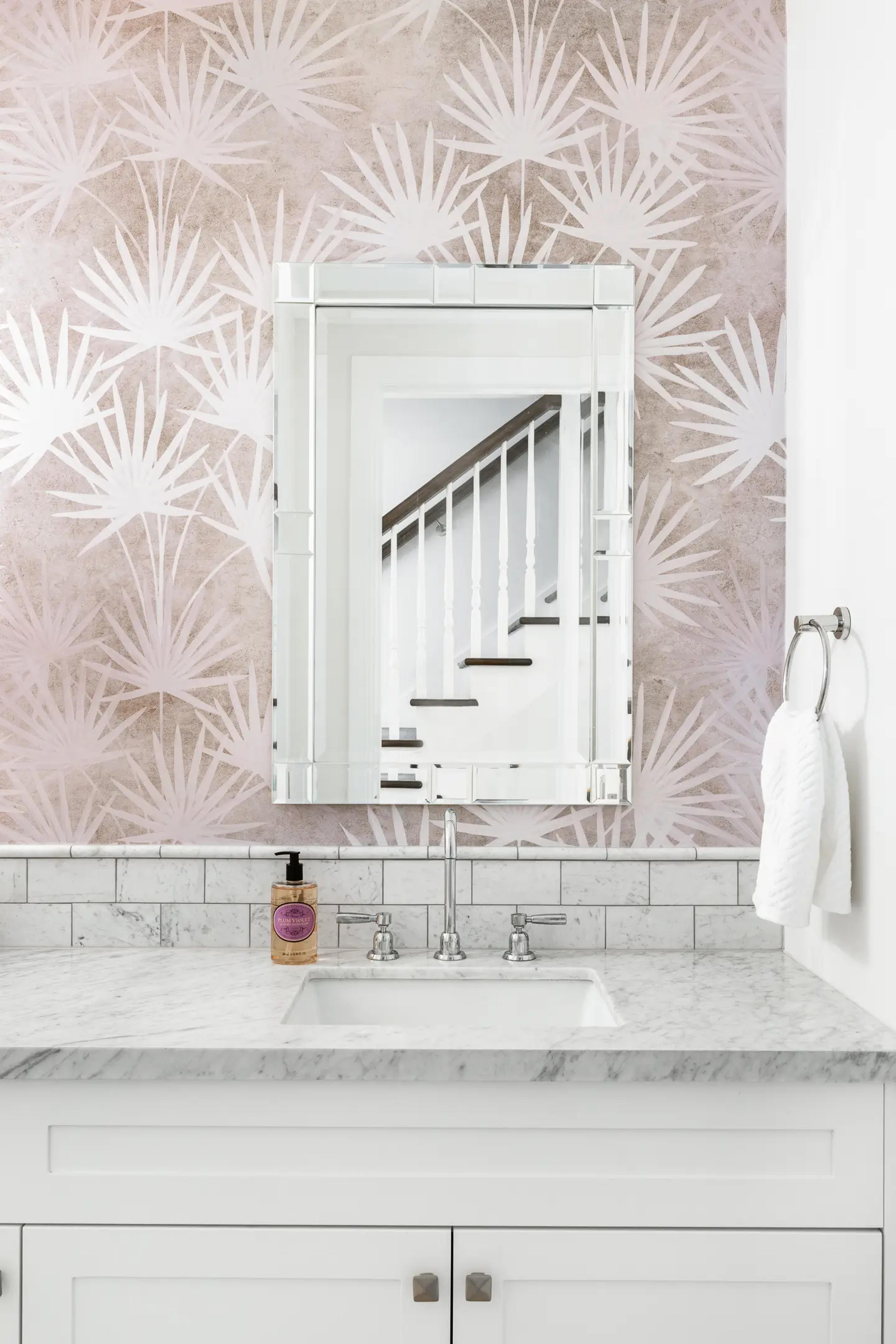 Powder room with palm print wallpaper and marble vanity