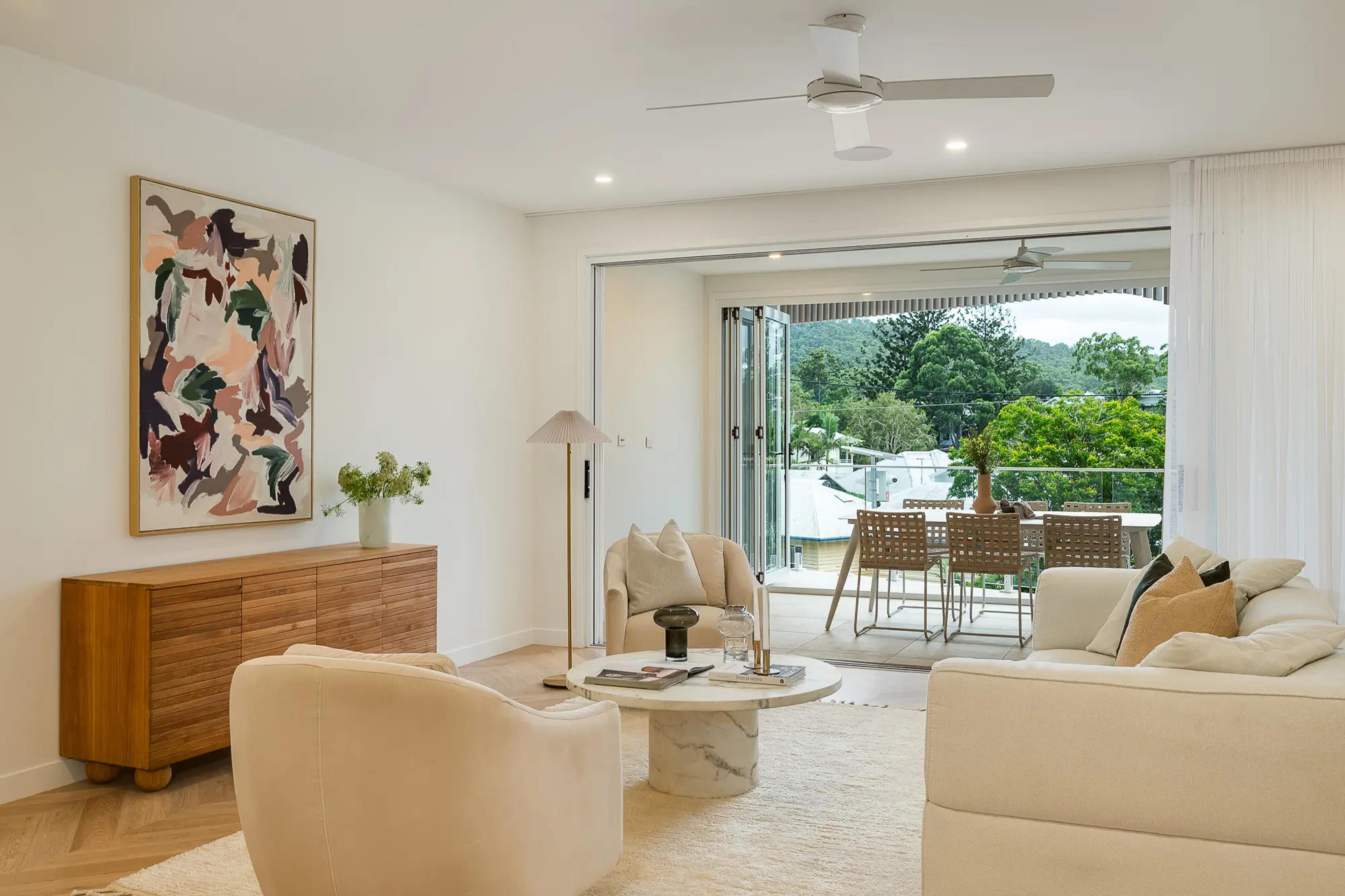 Living room opening to balcony with hilly view
