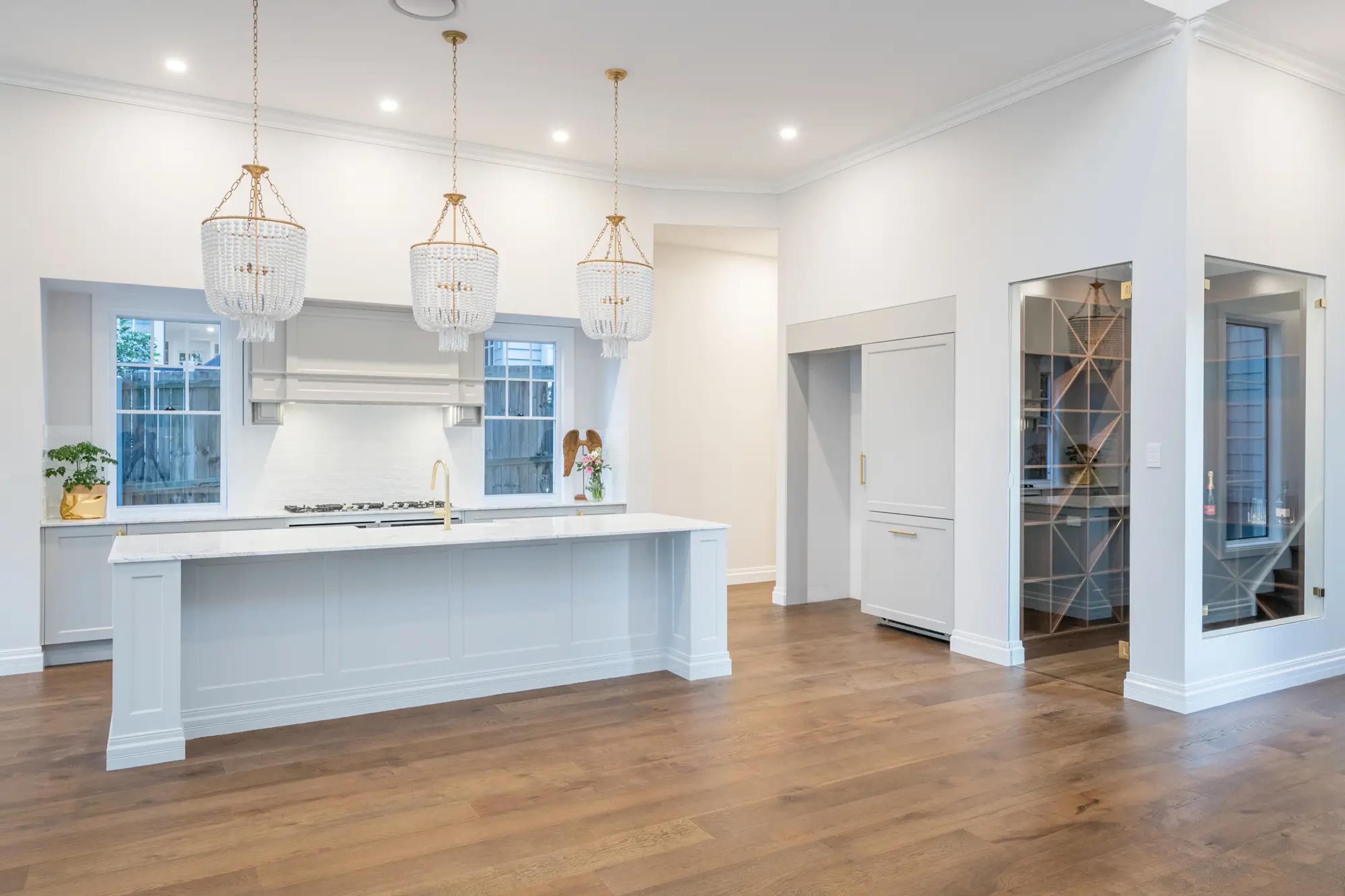 Open plan kitchen with white island and beaded pendant lights