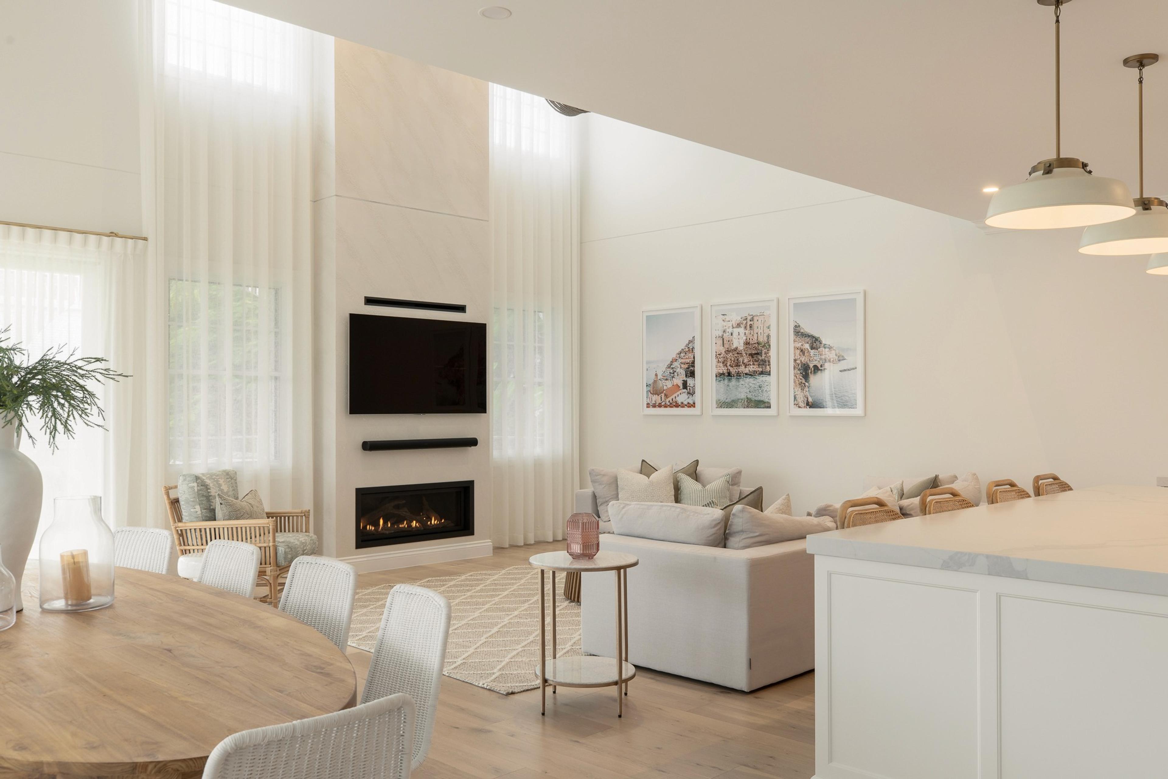 Double height living room with fireplace, mounted television and sofa
