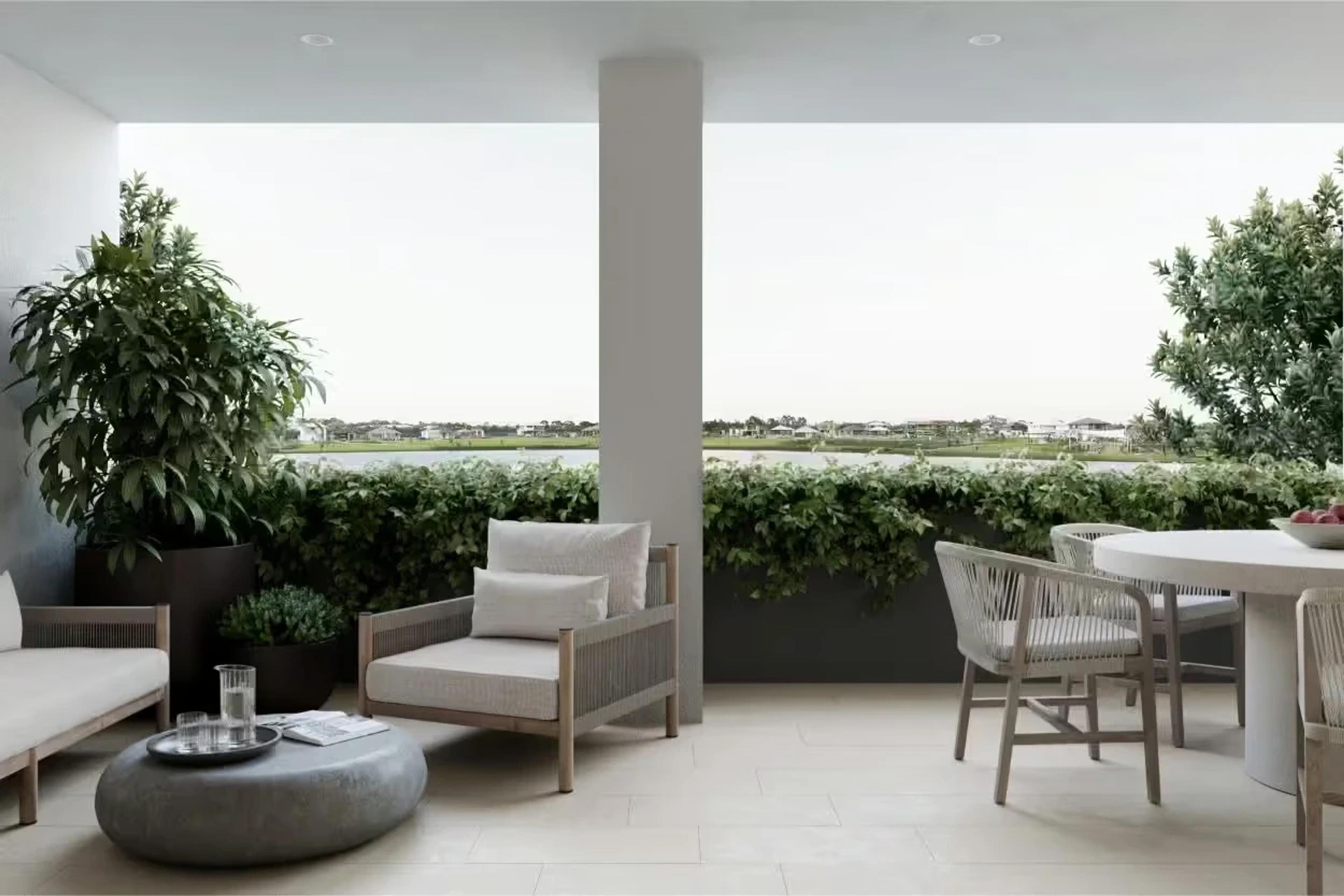 Covered terrace with lounge seating and dining setting overlooking greenery