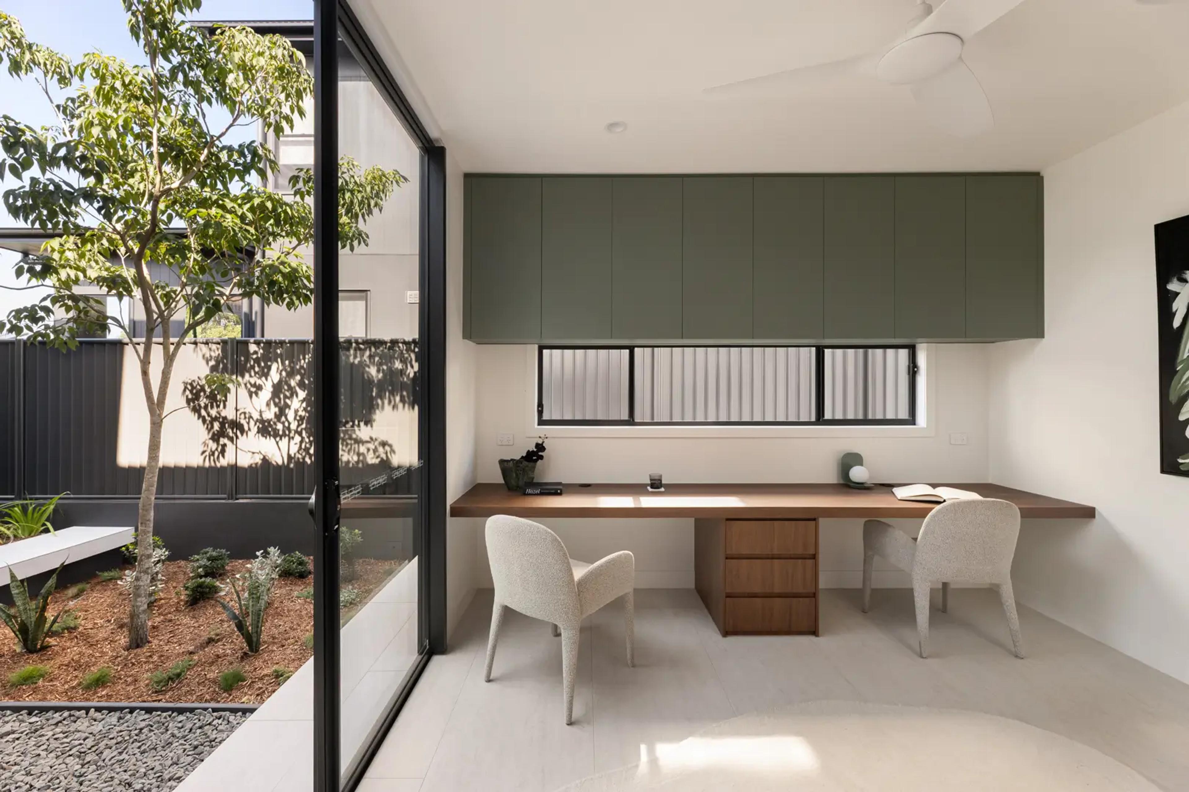Study desk beside glass wall with courtyard view