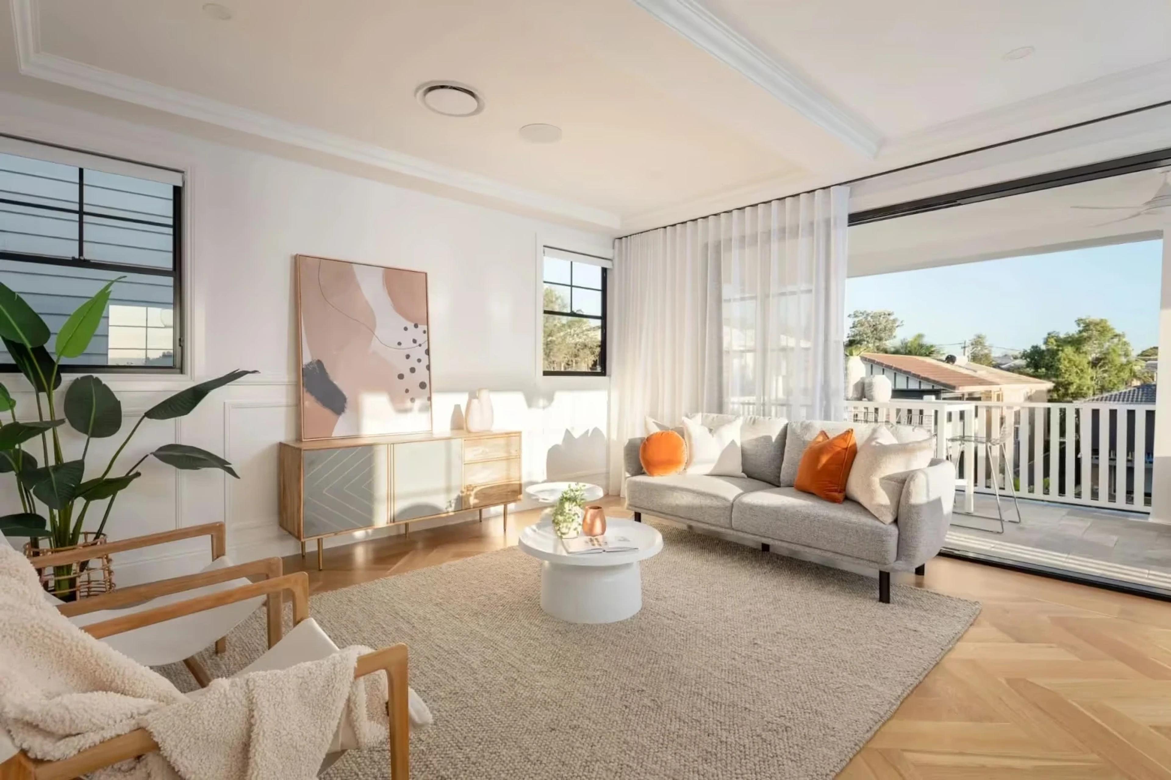 Bright lounge with sofa, artwork and balcony beyond sheer curtains