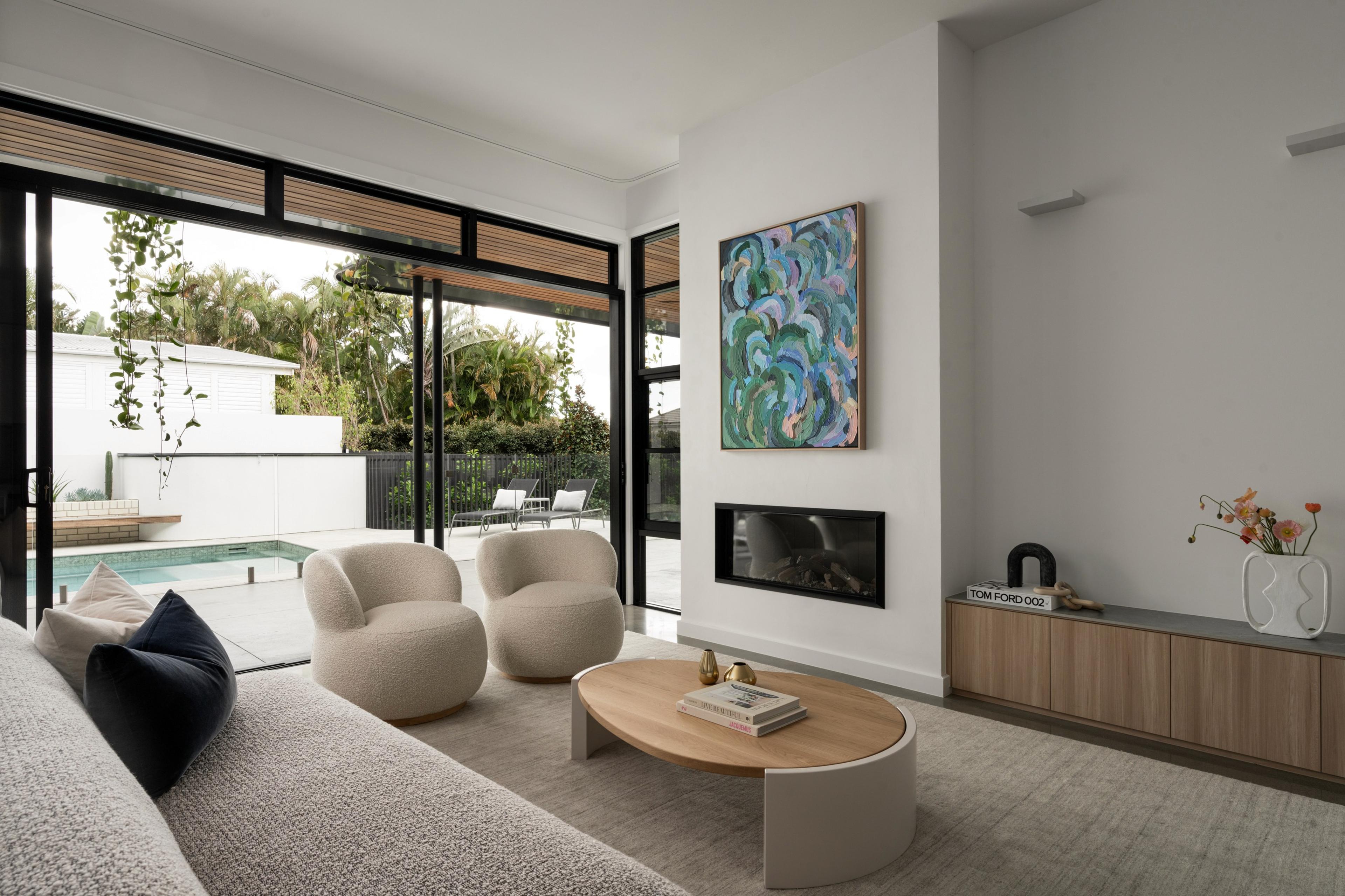 Living room with fireplace and glass doors opening to pool