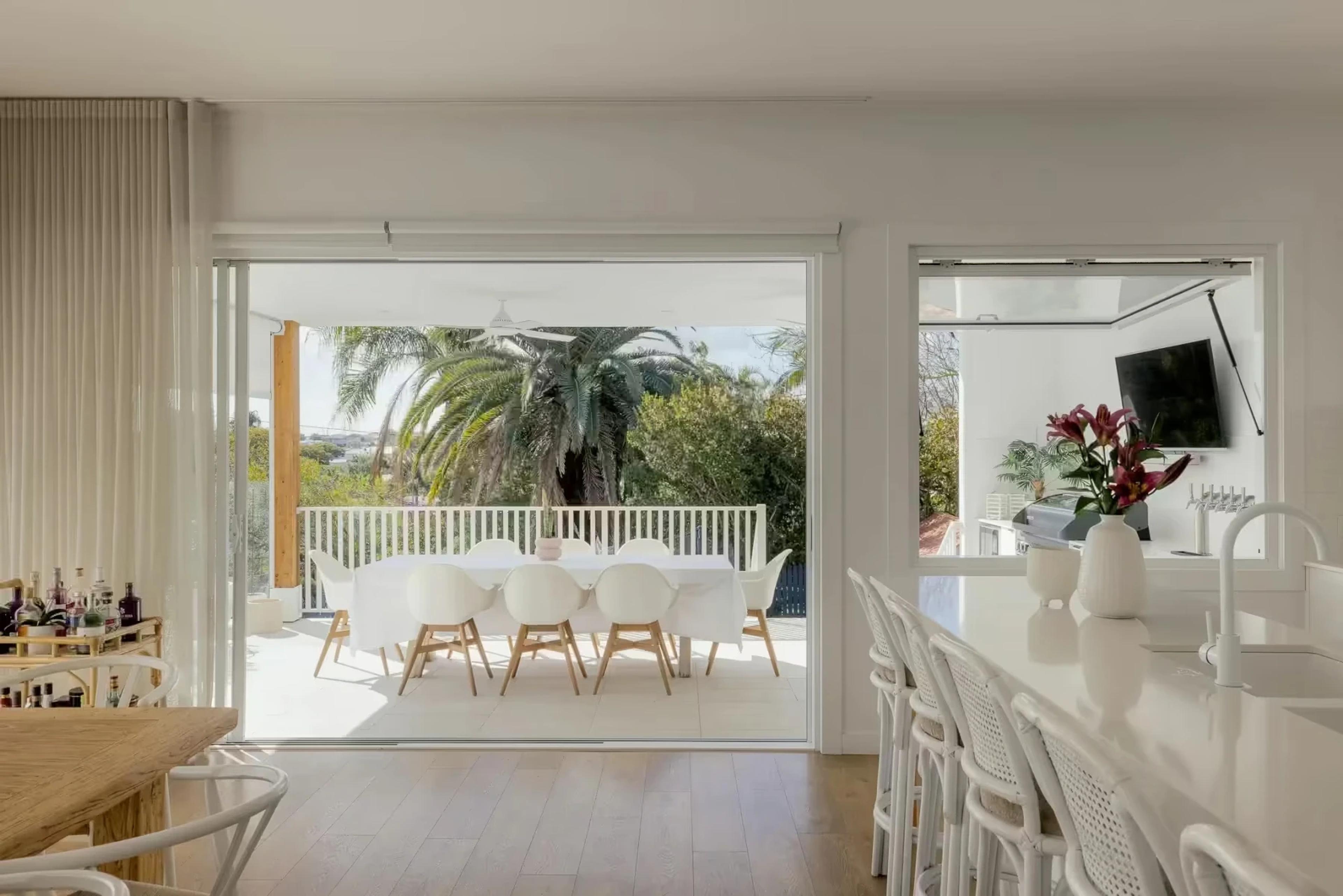 Dining area opening to covered outdoor terrace with palms