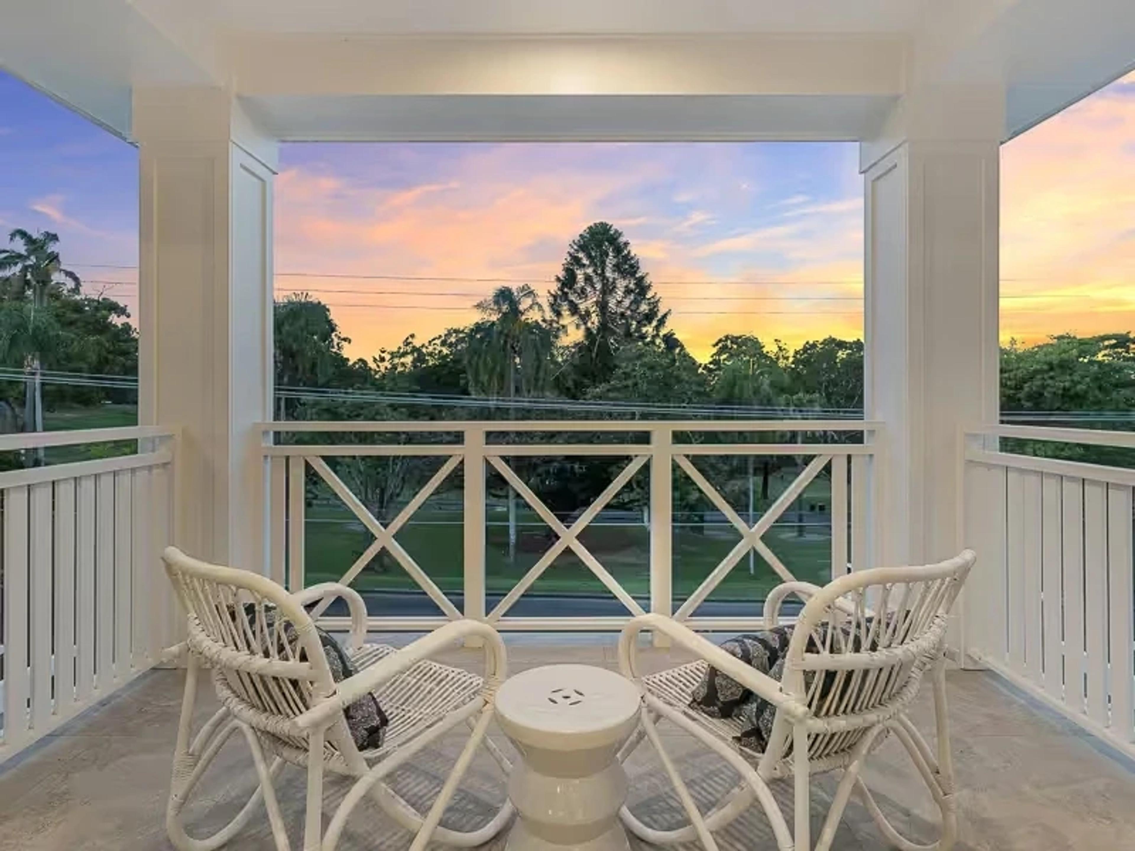 Balcony seating overlooking parkland at sunset