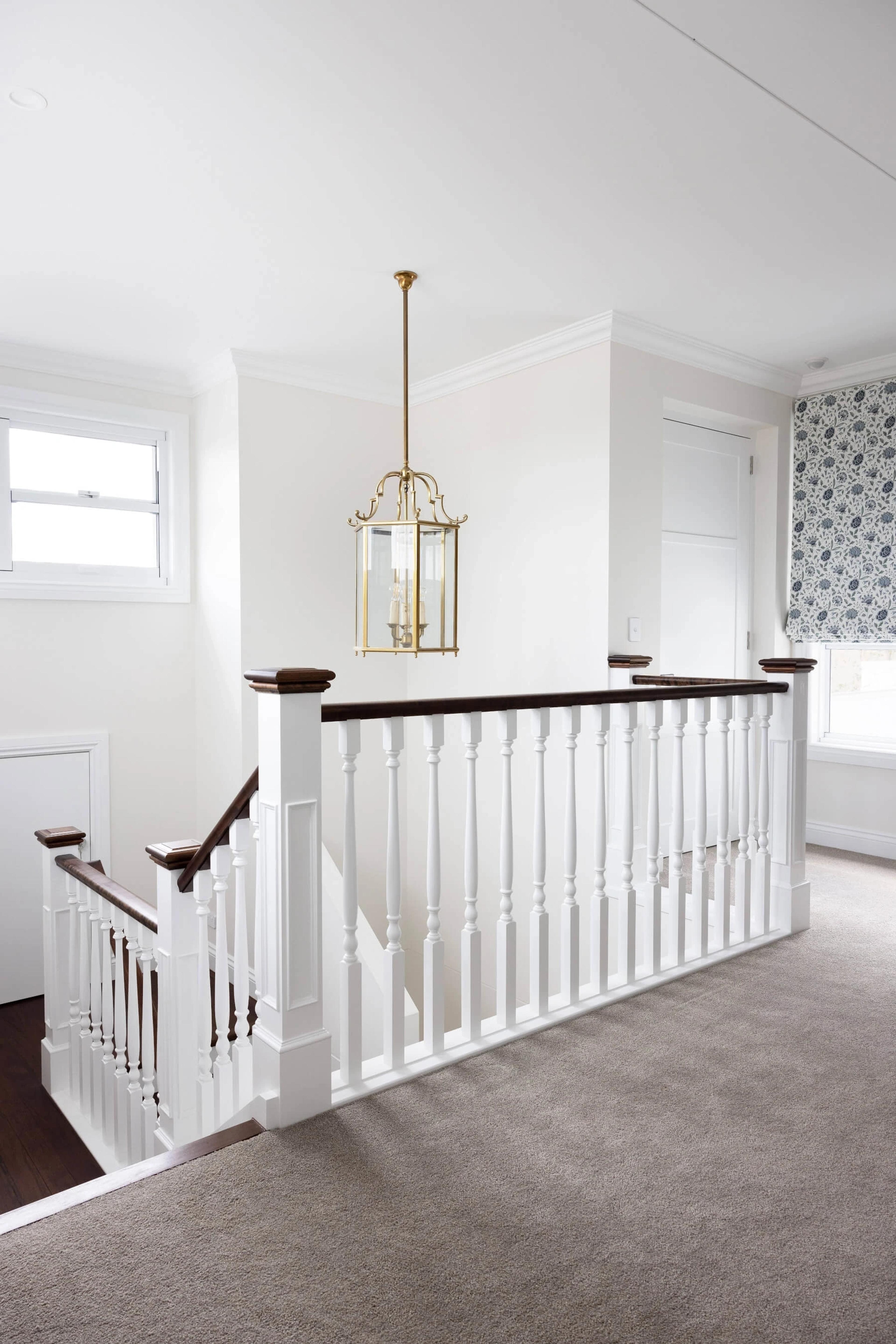 Carpeted upstairs landing with white timber balustrade