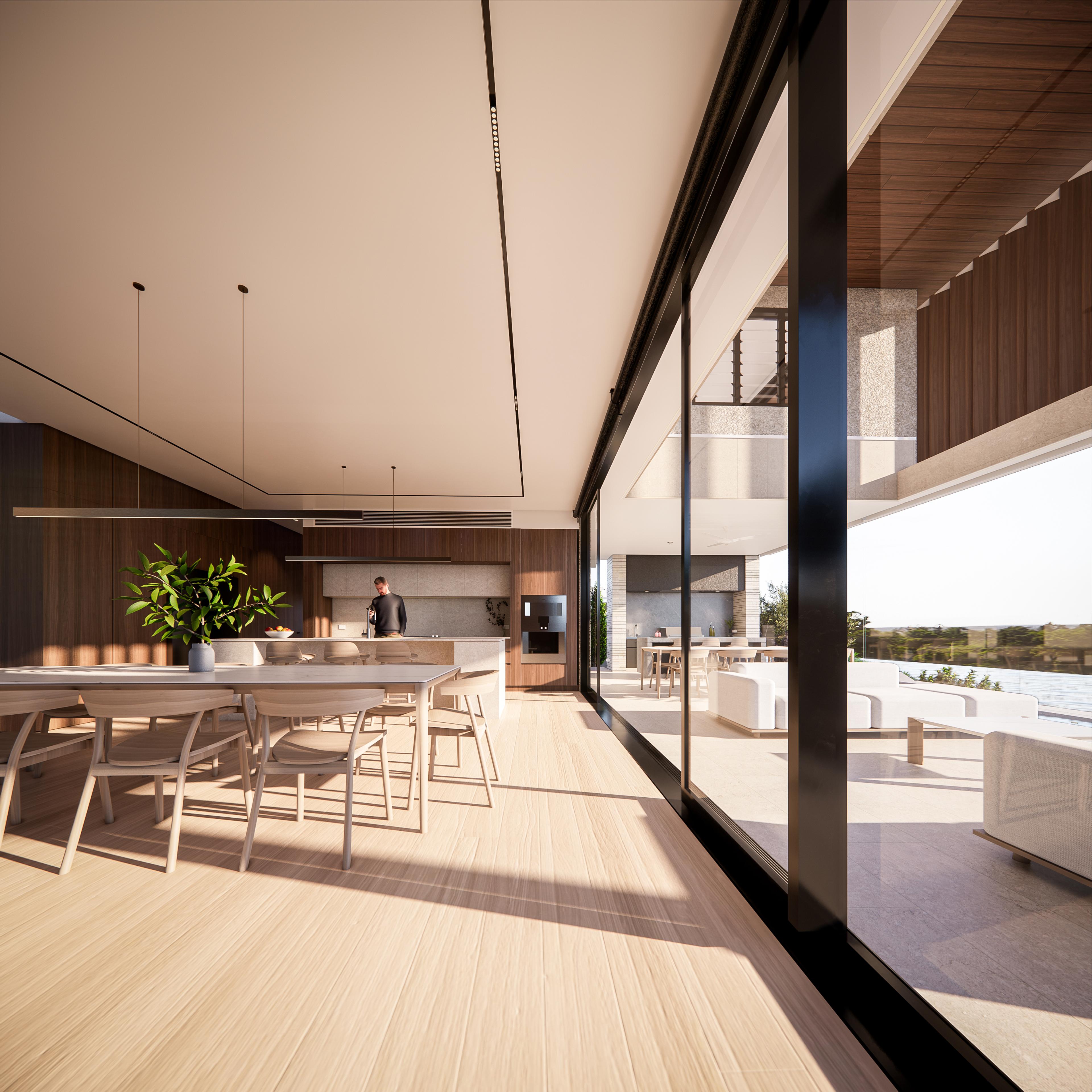 Long timber dining table beside a walnut kitchen with stone island and floor to ceiling glass