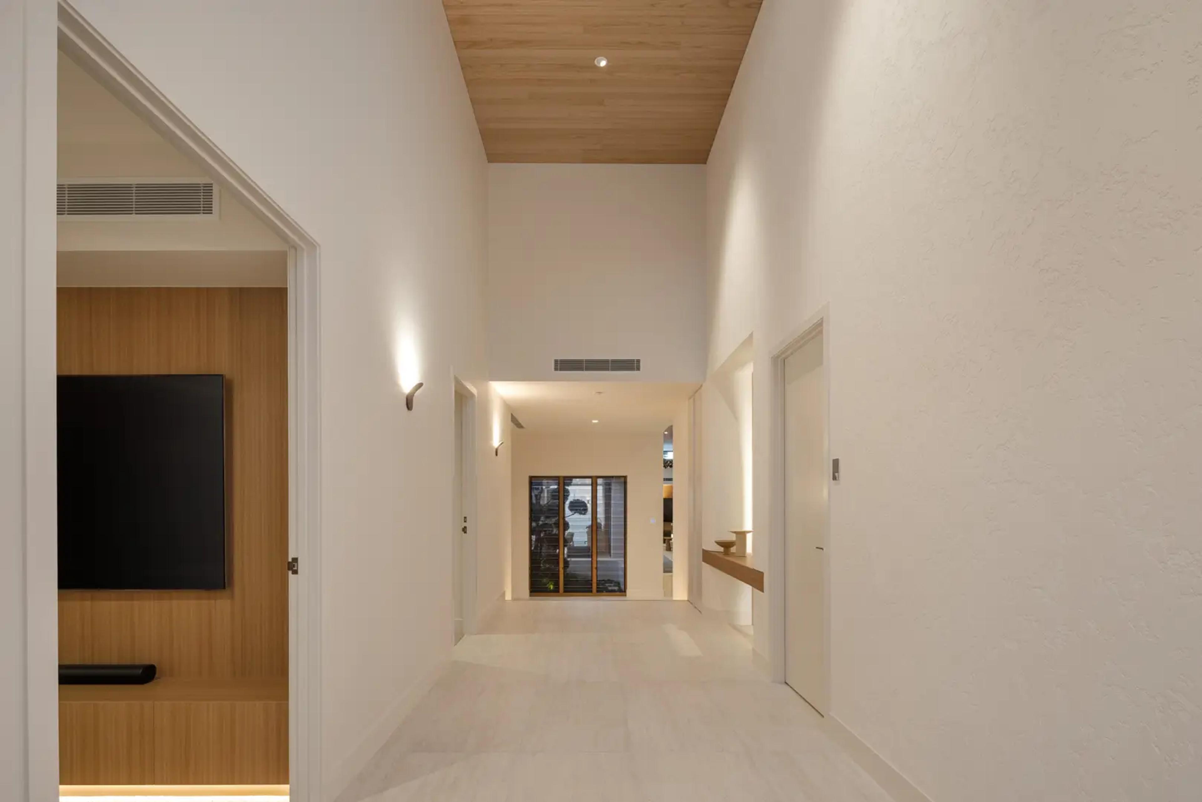Tall white hallway with timber joinery and skylight