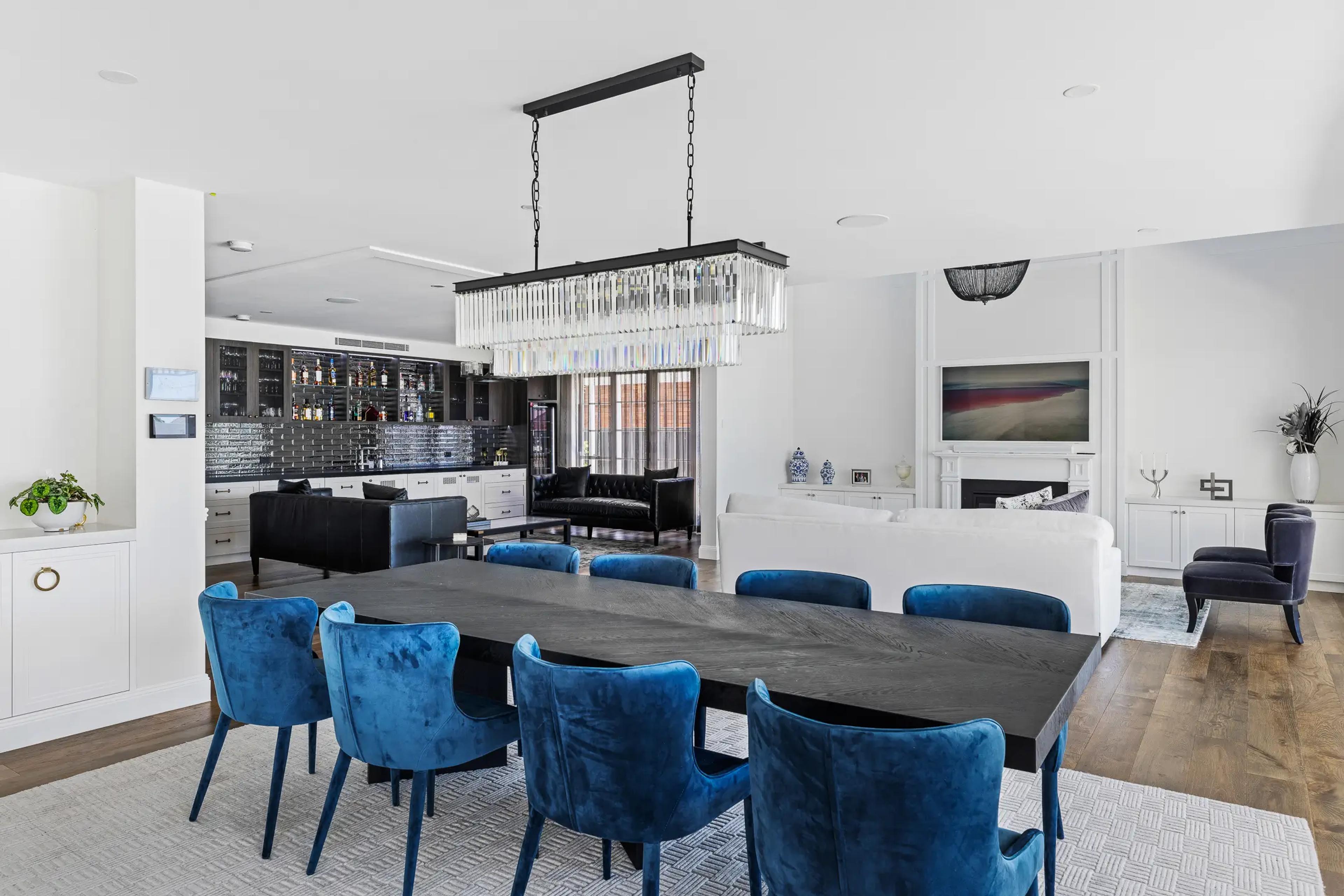 Dining room with blue velvet chairs and bar beyond